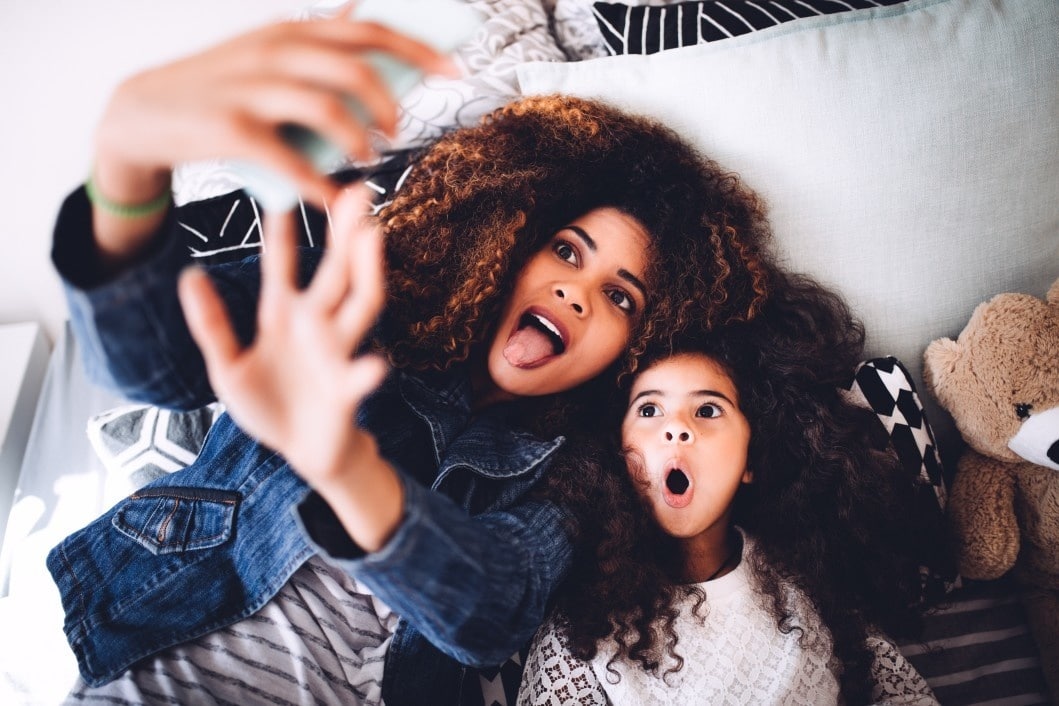 mom and daughter making silly faces for a selfie- finding joy in motherhood