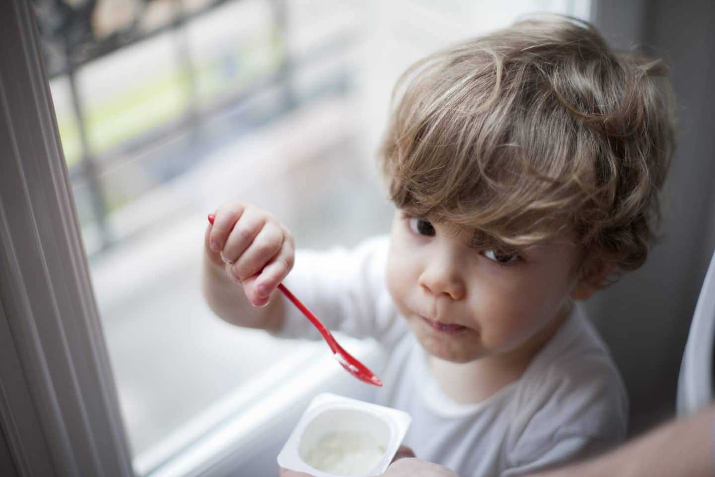 little boy eating yogurt