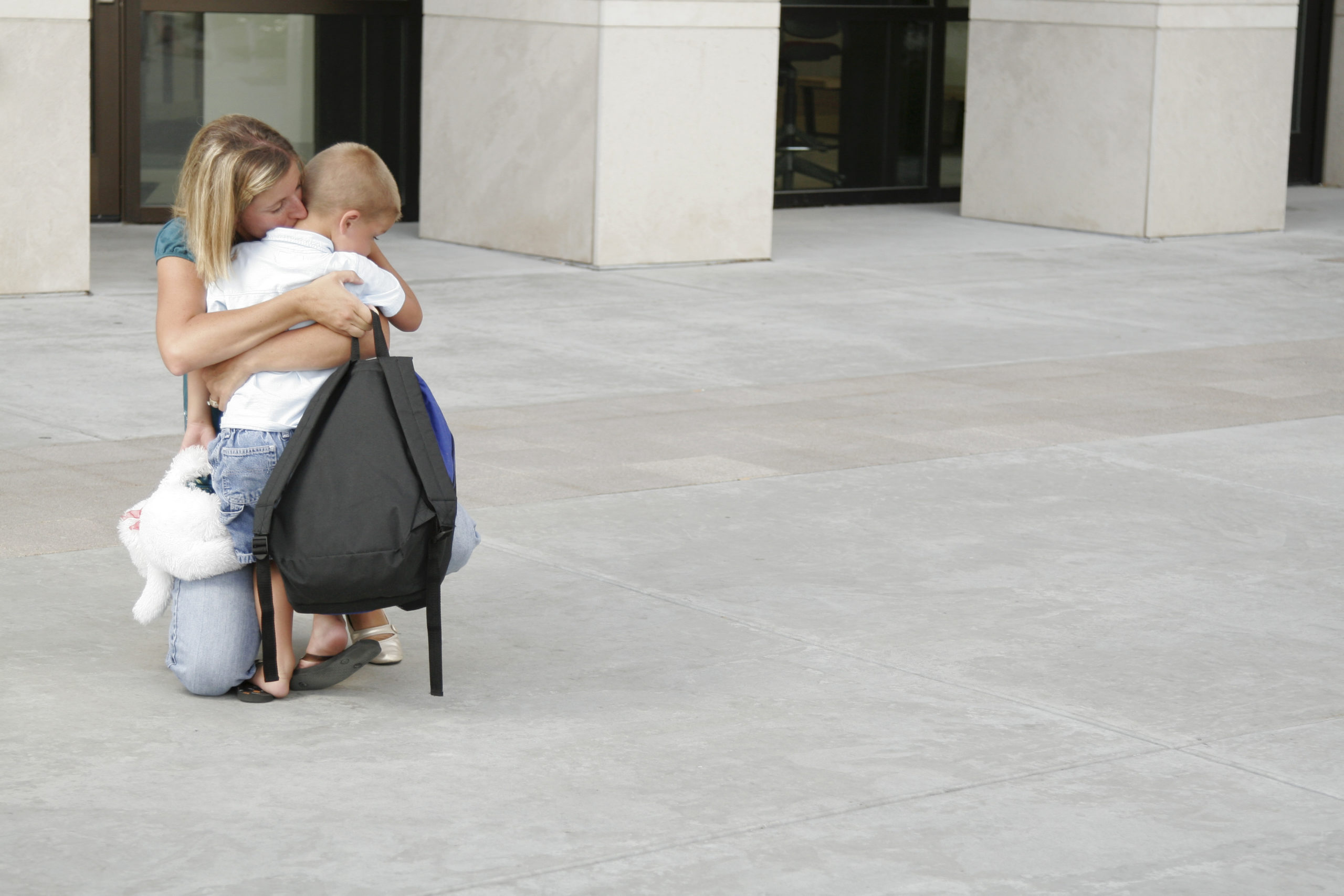 mom hugging son outside of school