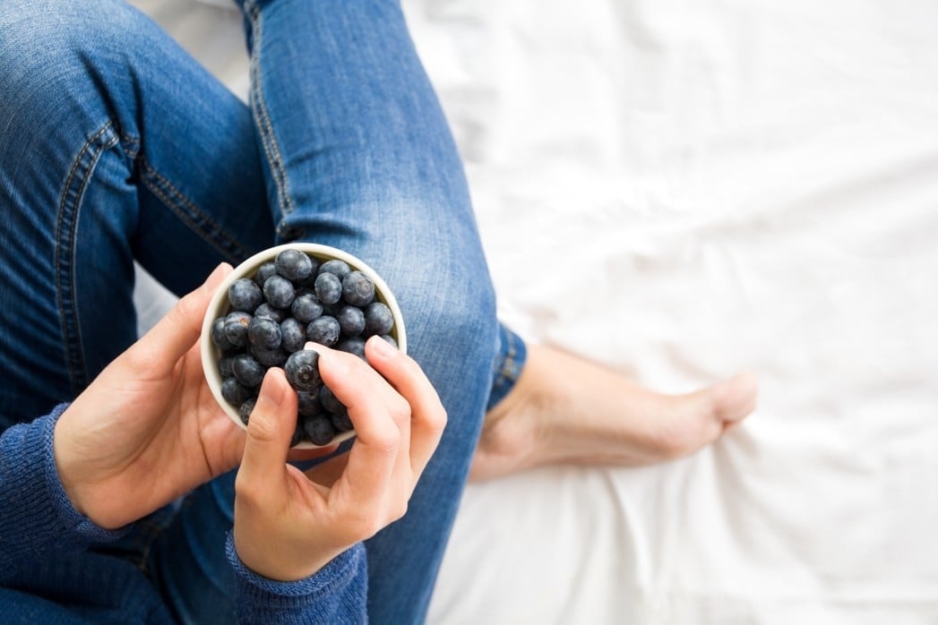 morning sickness nutrition: woman eating blueberries