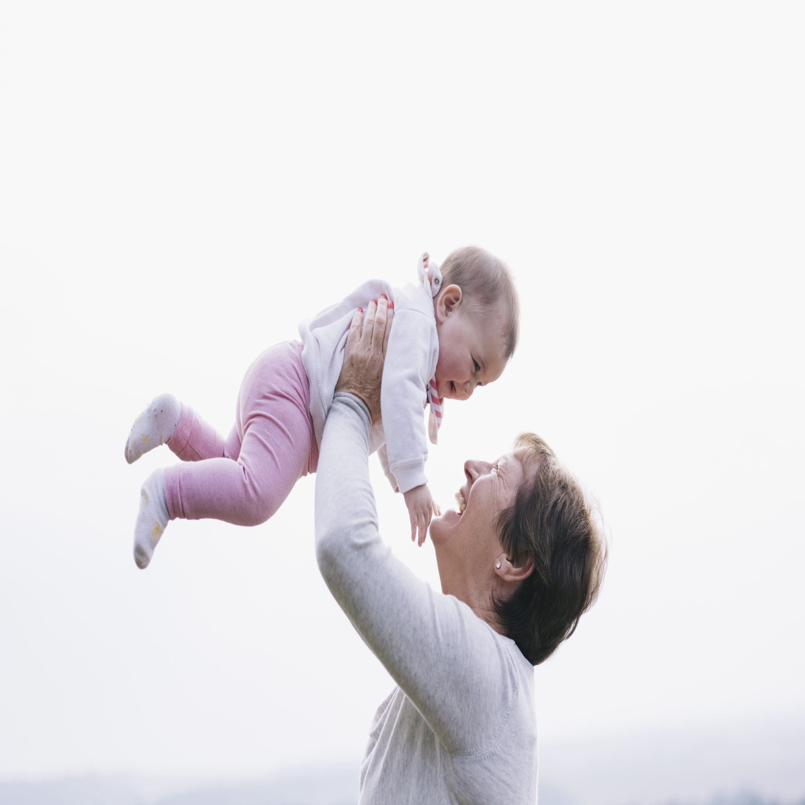 Grandma throwing granddaughter in the air