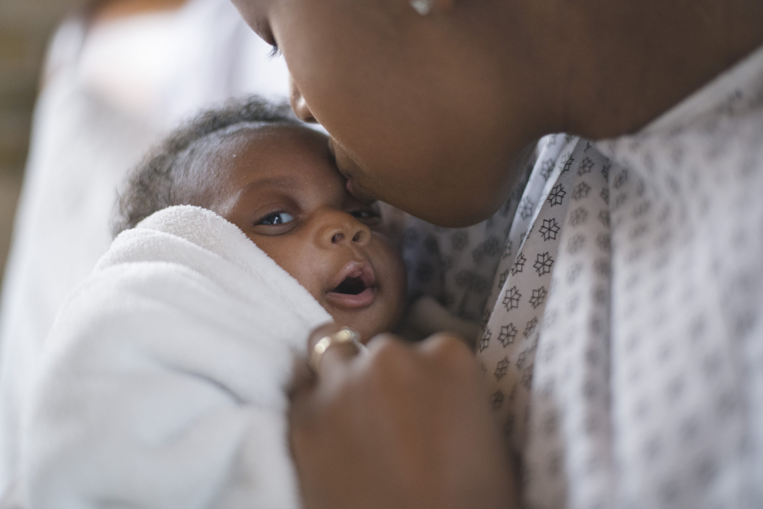 mom kissing newborn baby on the head