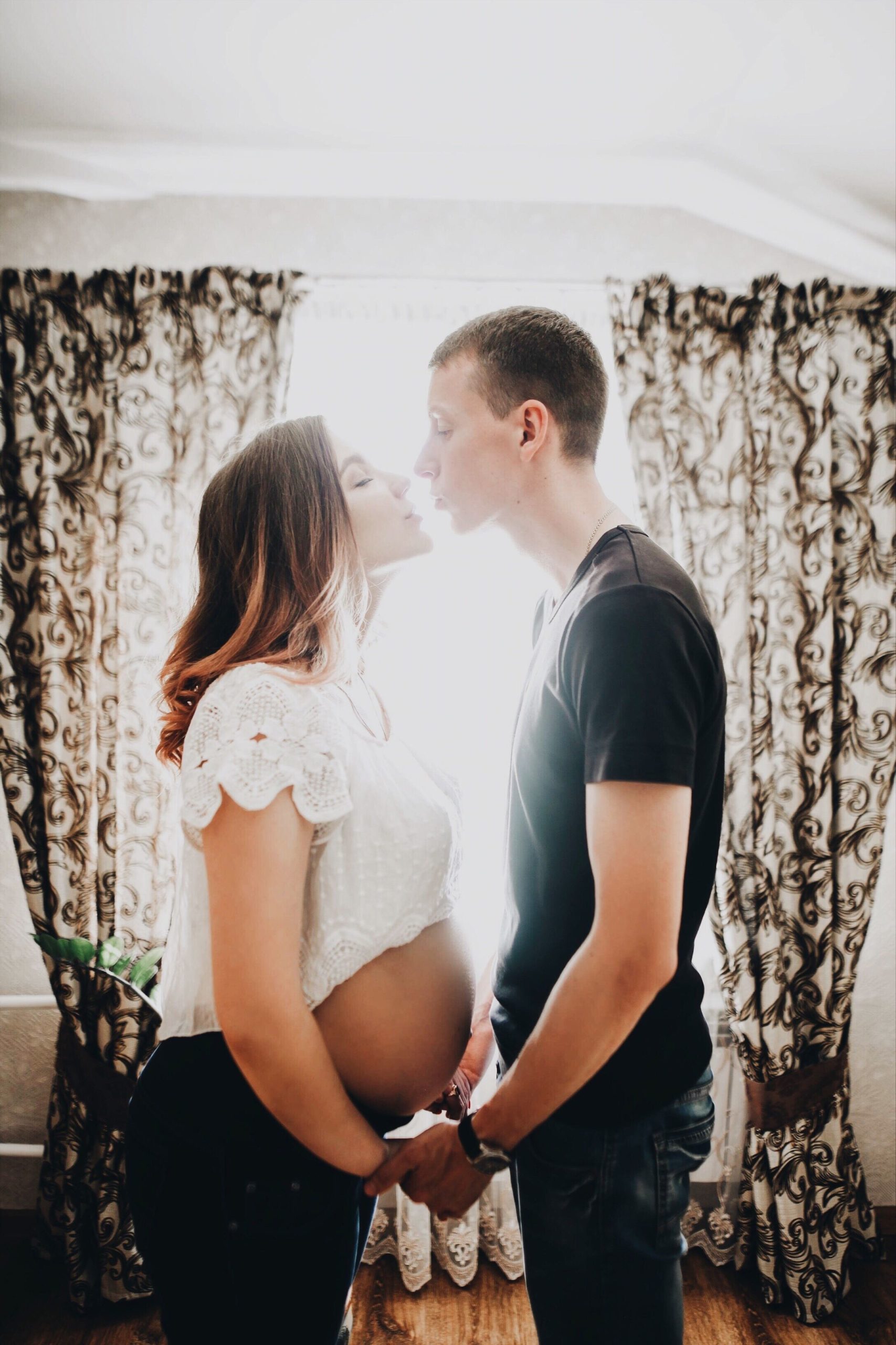 pregnant woman kissing her partner