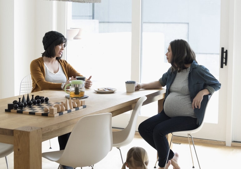 two moms sitting at a table together