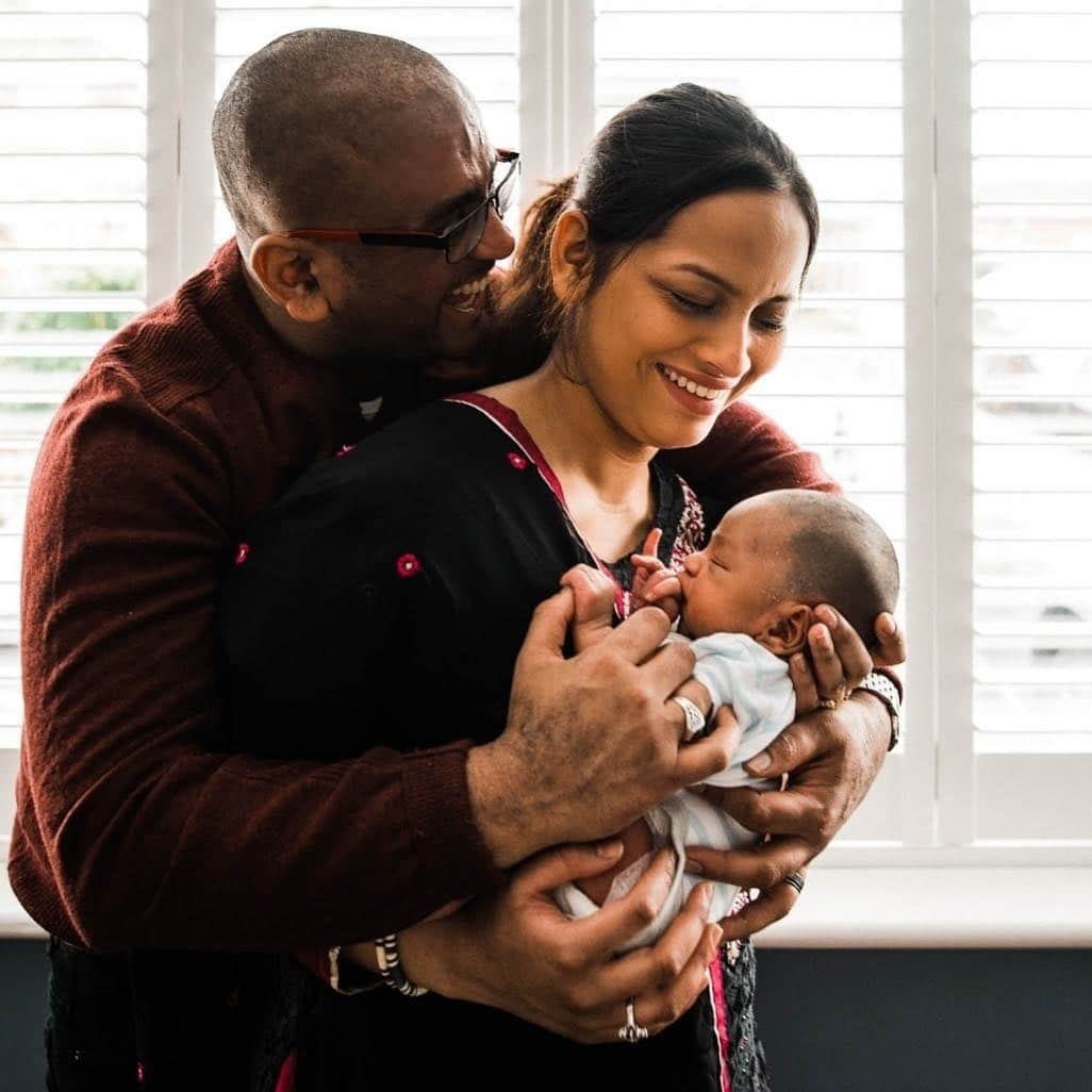 man and woman holding newborn baby