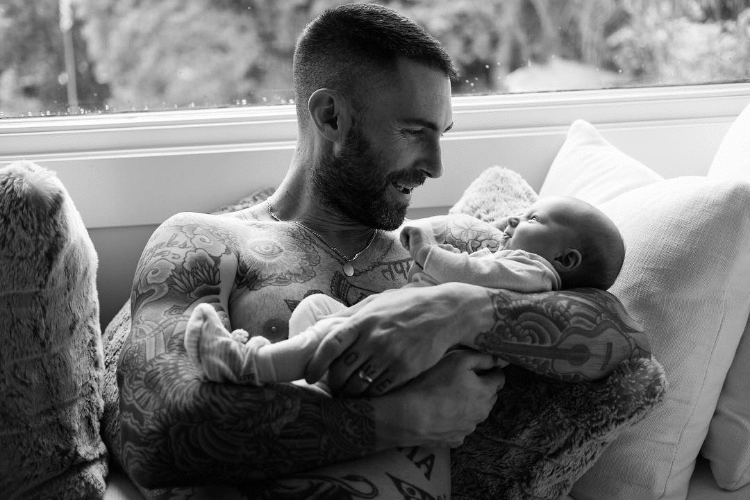 Adam Levine holding his baby