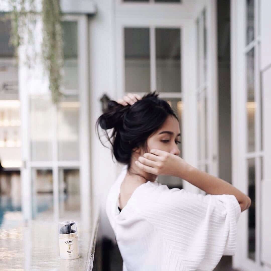 woman putting her hair in a bun