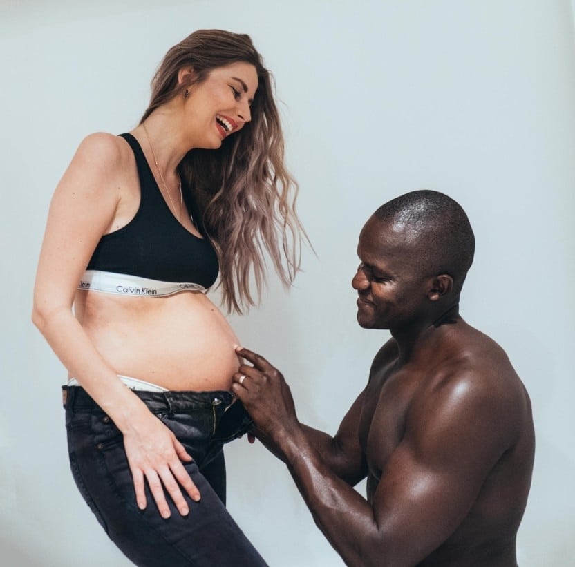 man touching his partner pregnant belly