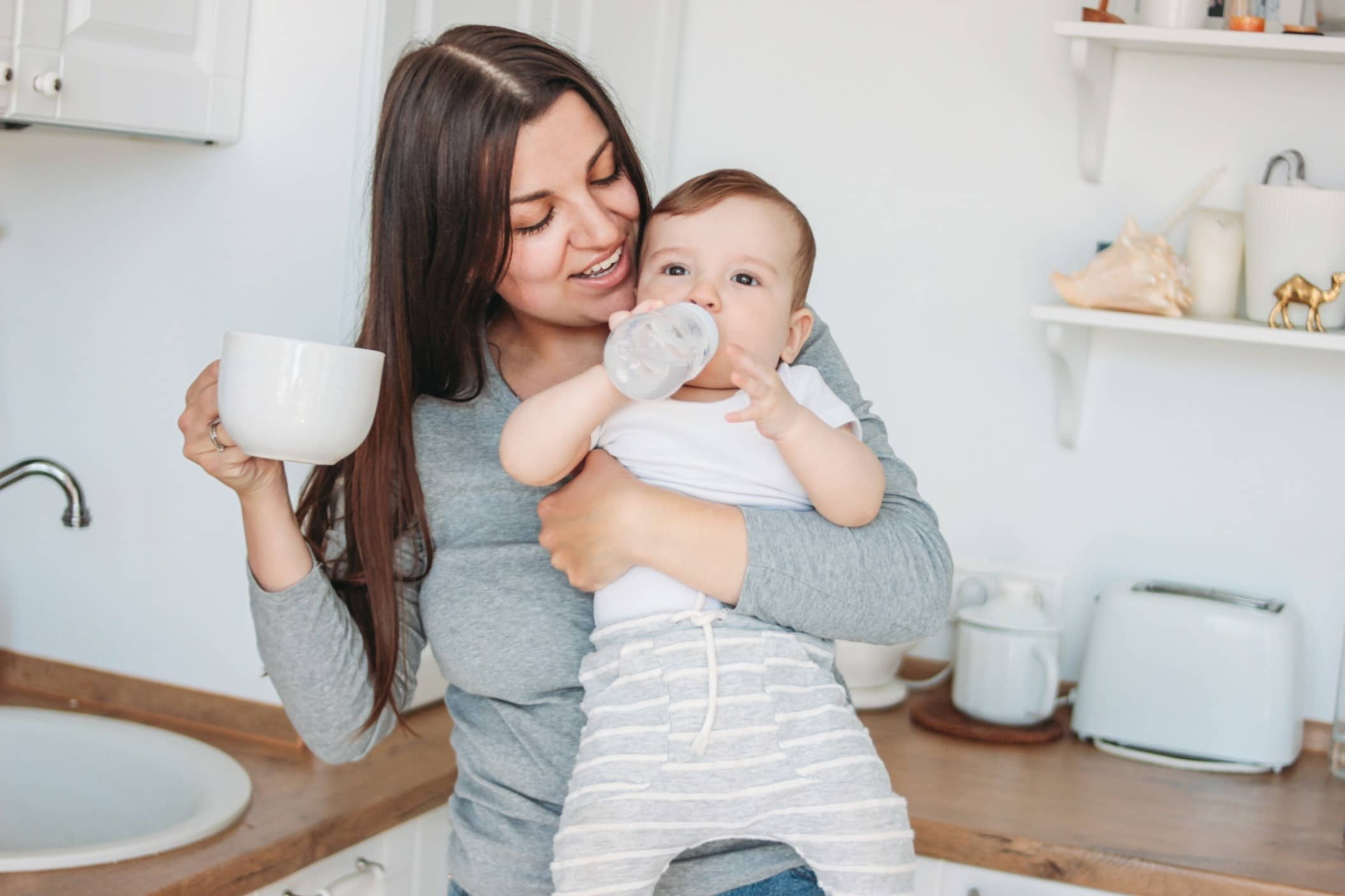 mom giving a baby a bottle - why can't babies drink water