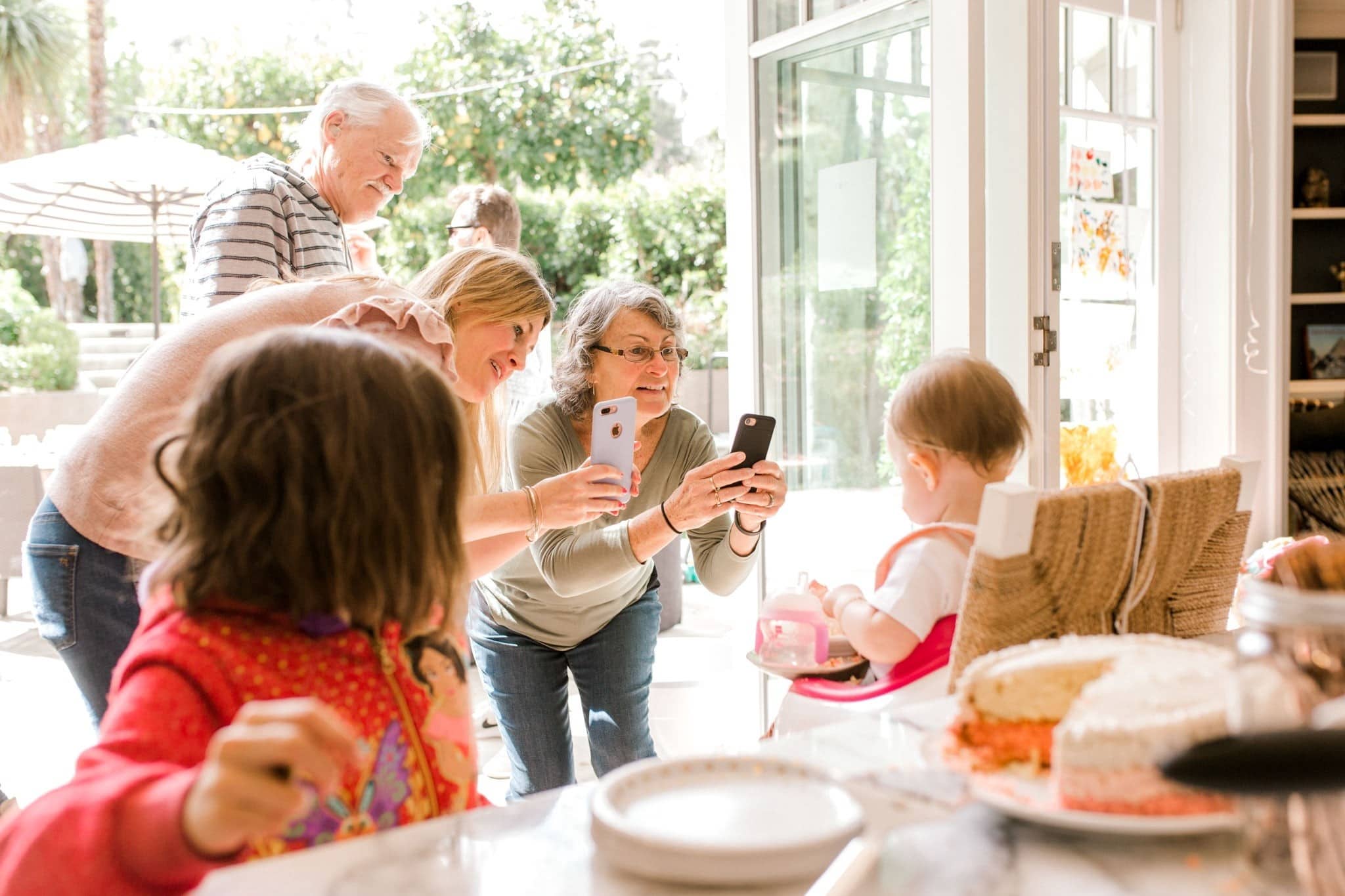 family taking pictures on their phone of a child