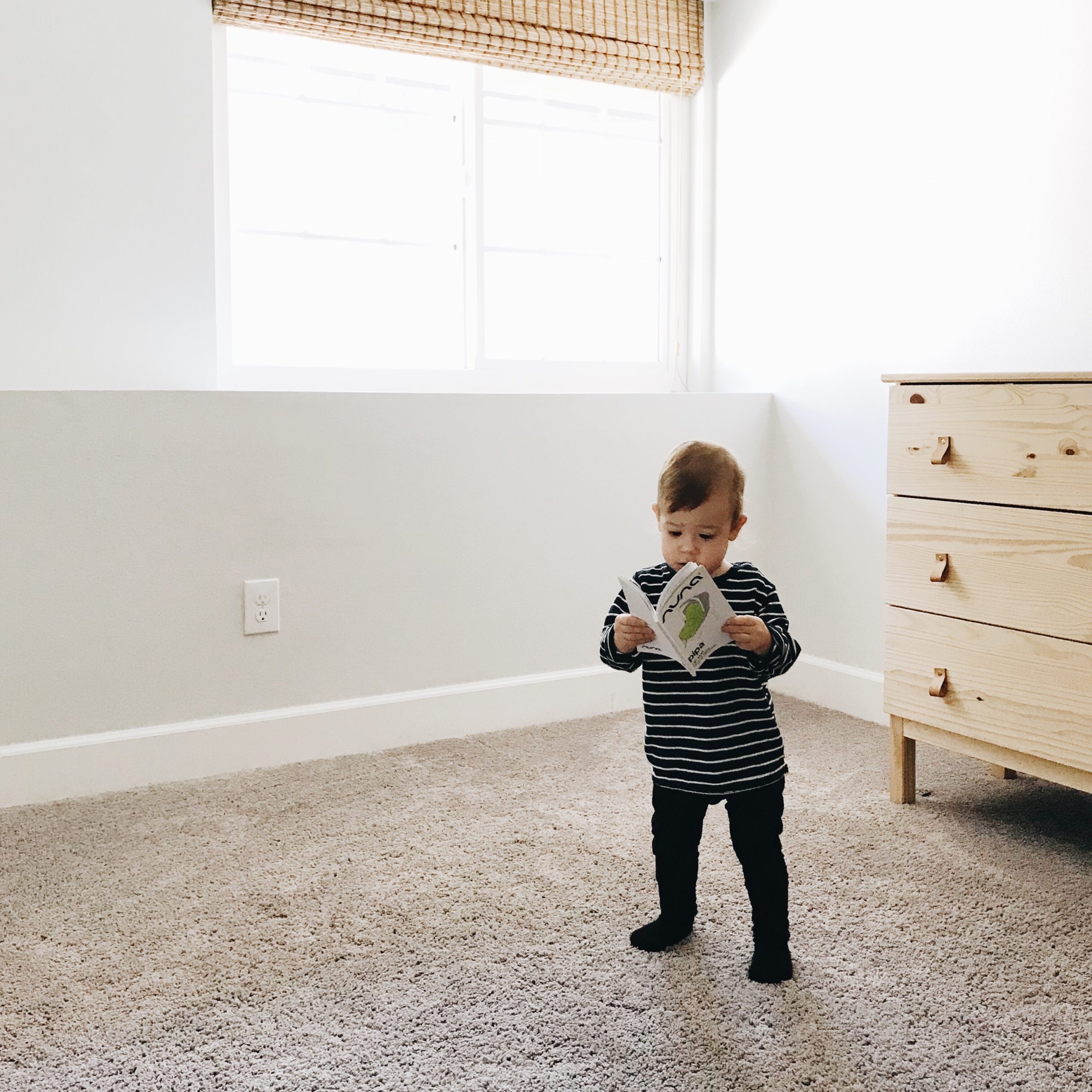 little boy standing with a book