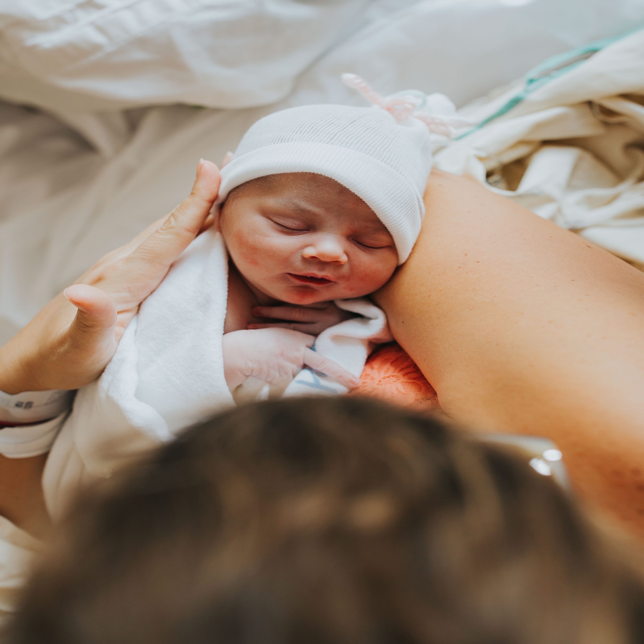 mom holding swaddled newborn