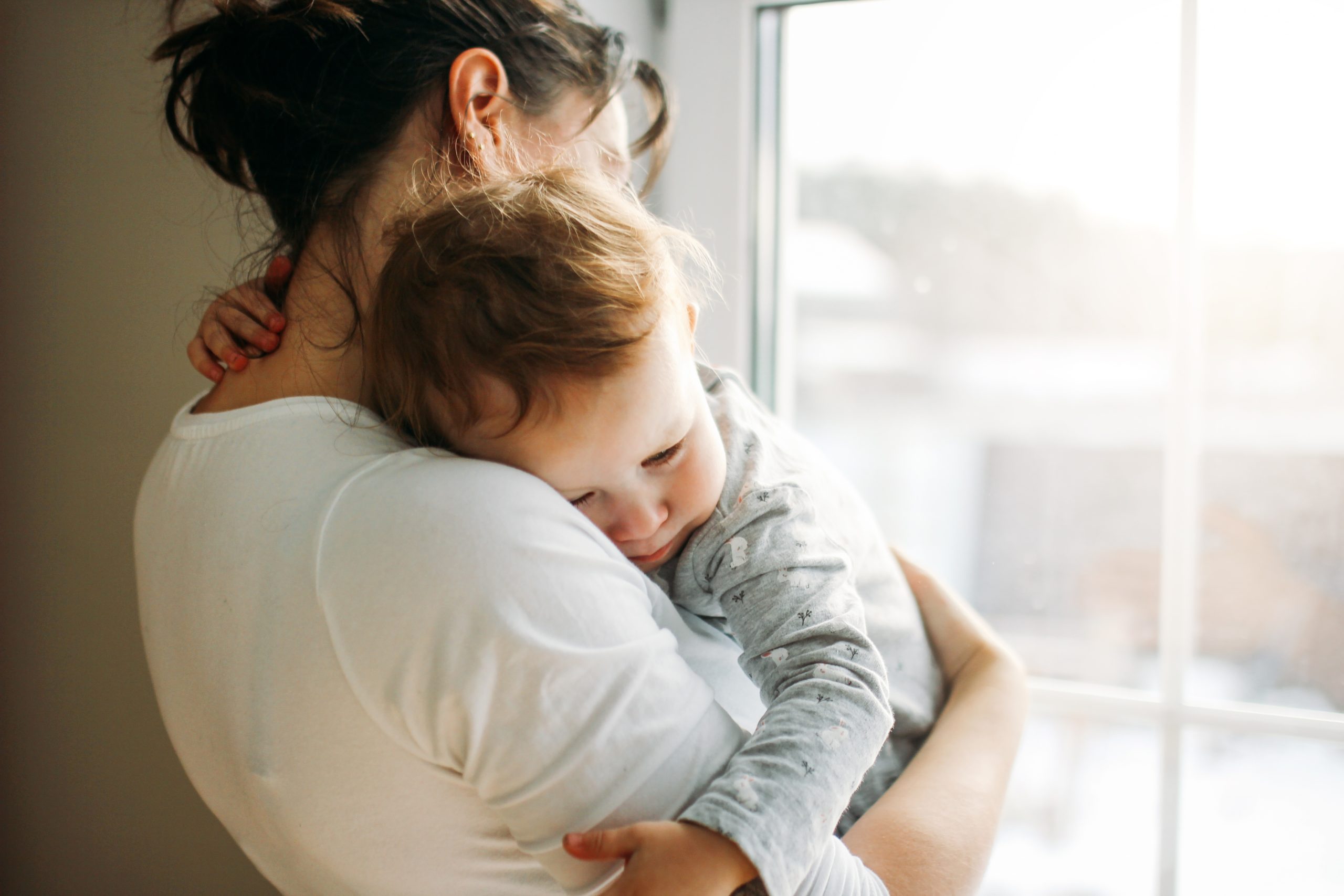 single mom holding baby against her shoulder