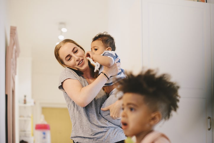 mom on the phone while juggling two kids