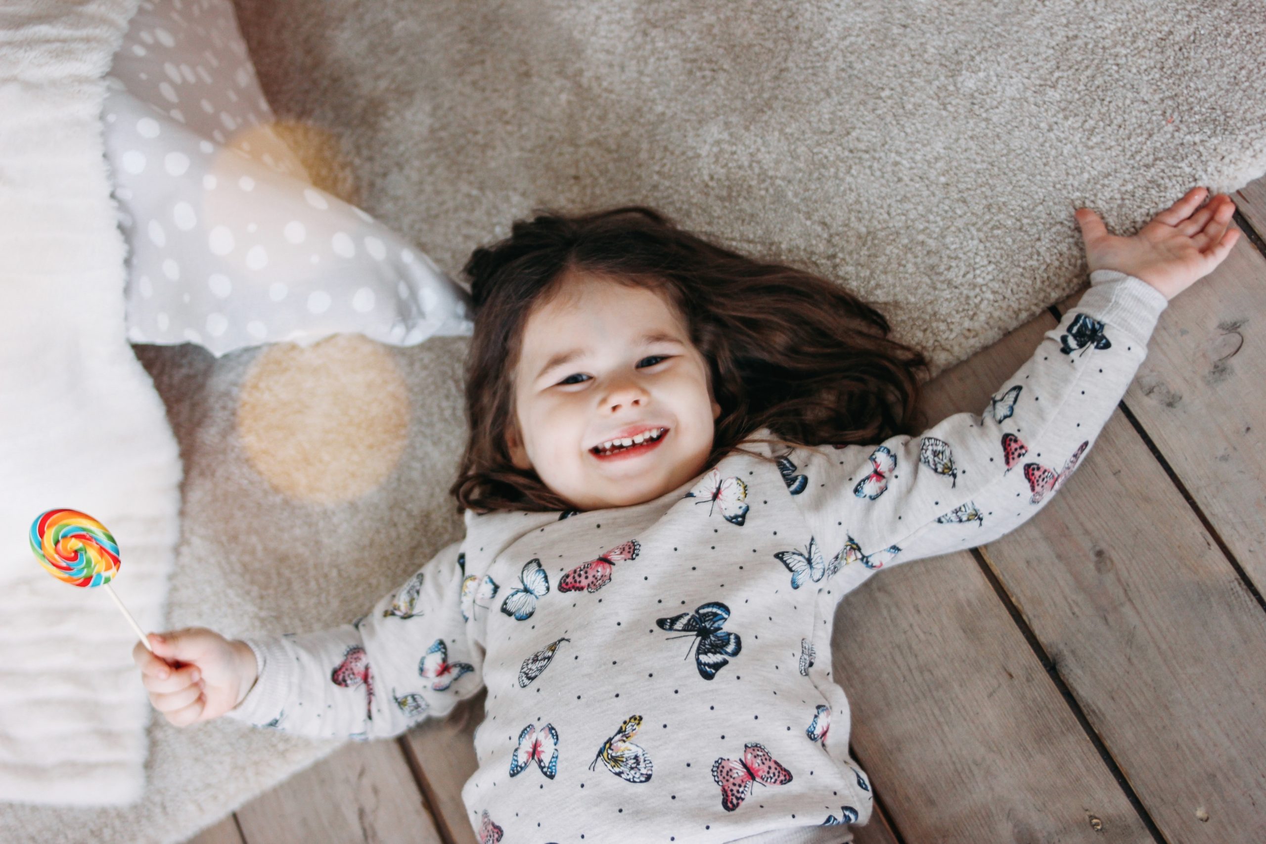 little girl laying down smiling- my greatest accomplishment is being a mom