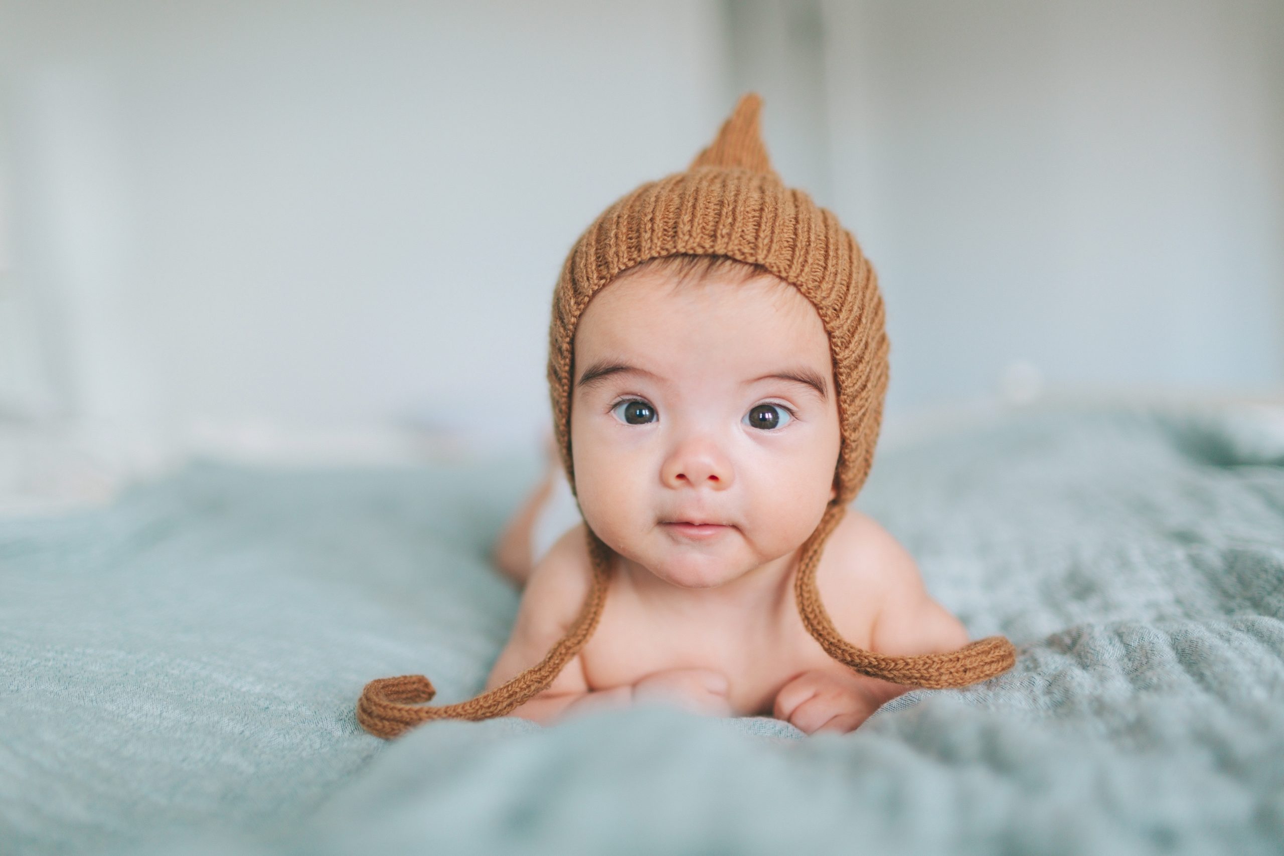 newborn baby doing tummy time and looking at the camera