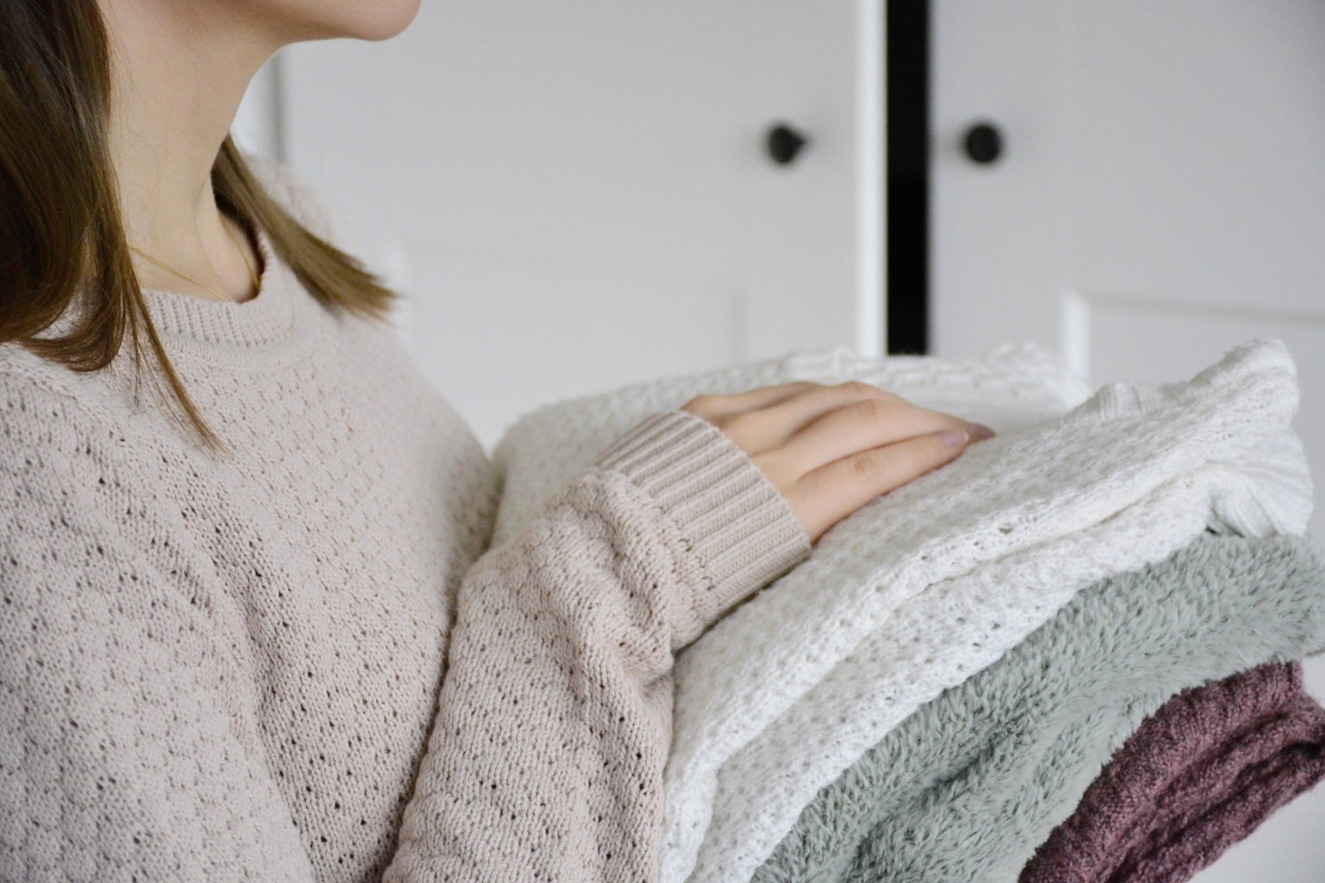 mom holding folded sweaters