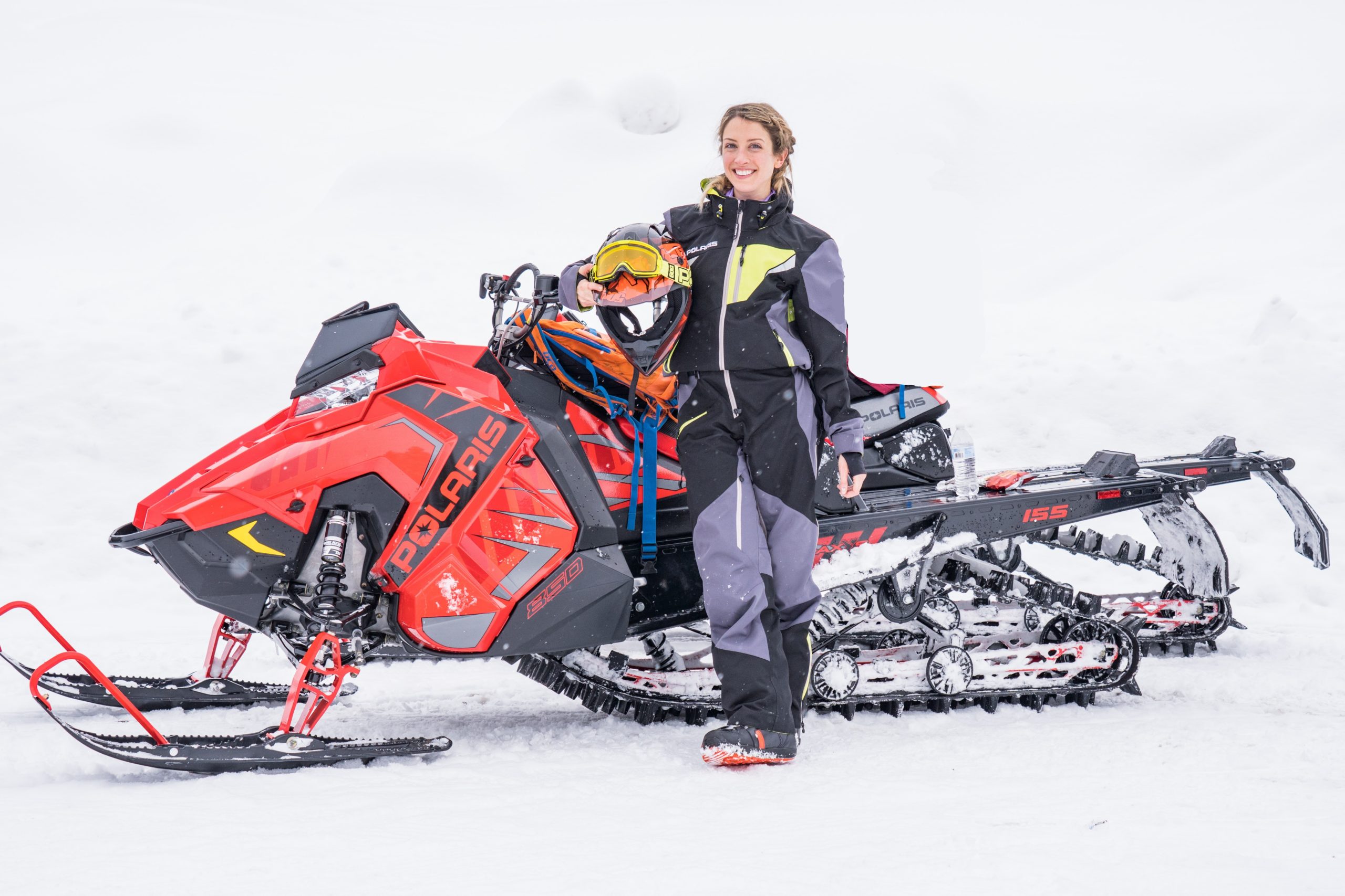 woman standing next to a snowmobile