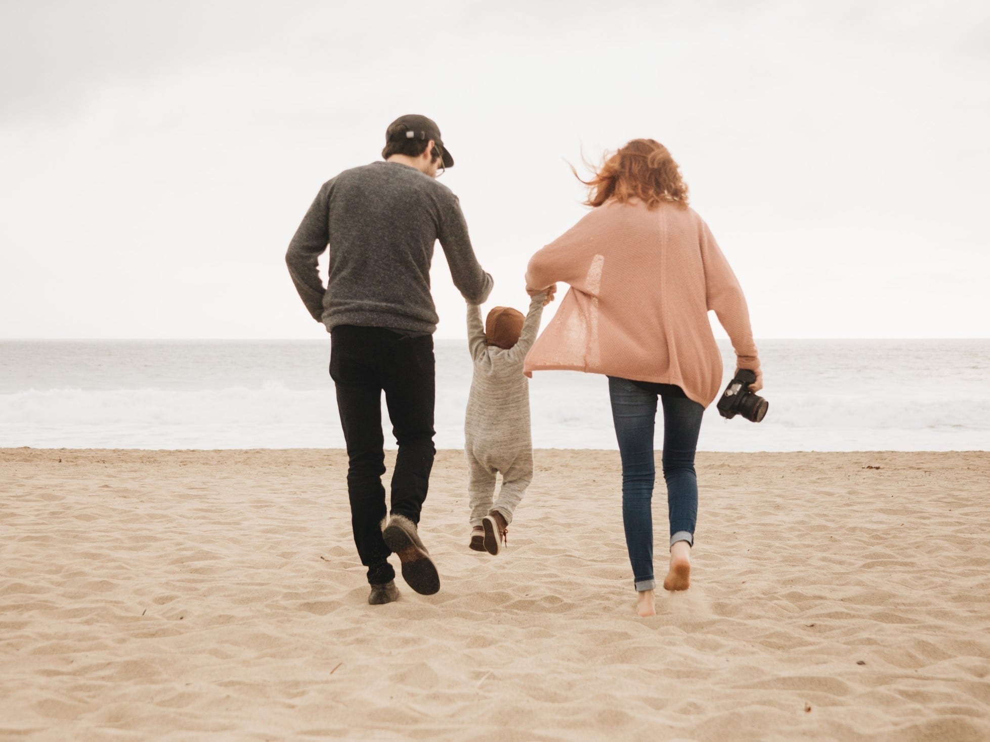 couple swinging toddler in the air