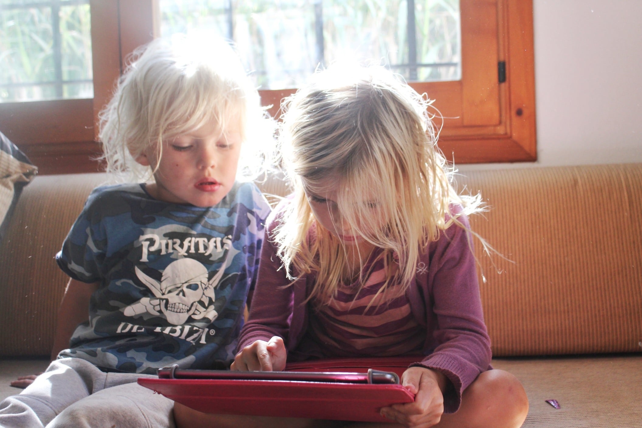 siblings playing on a tablet