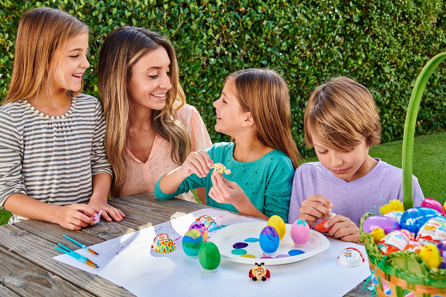 mom and kids decorating easter eggs