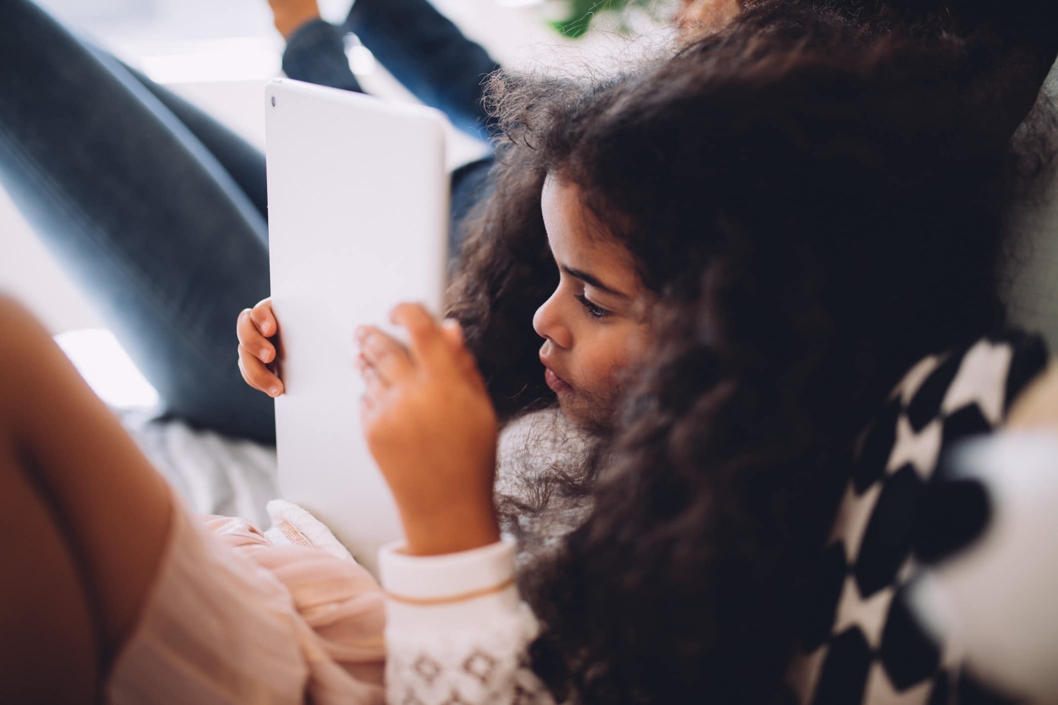 little girl playing on a tablet