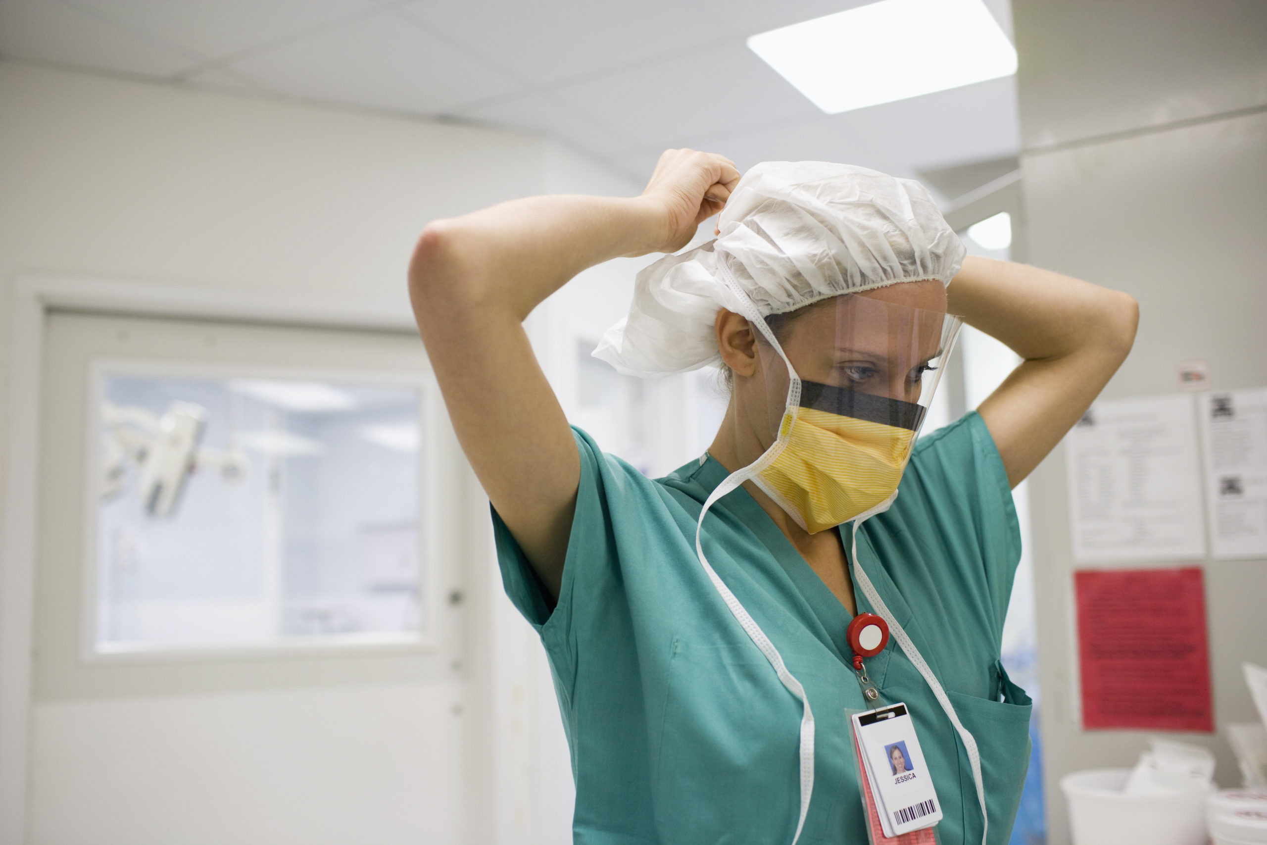 ER nurse tying her hair cap