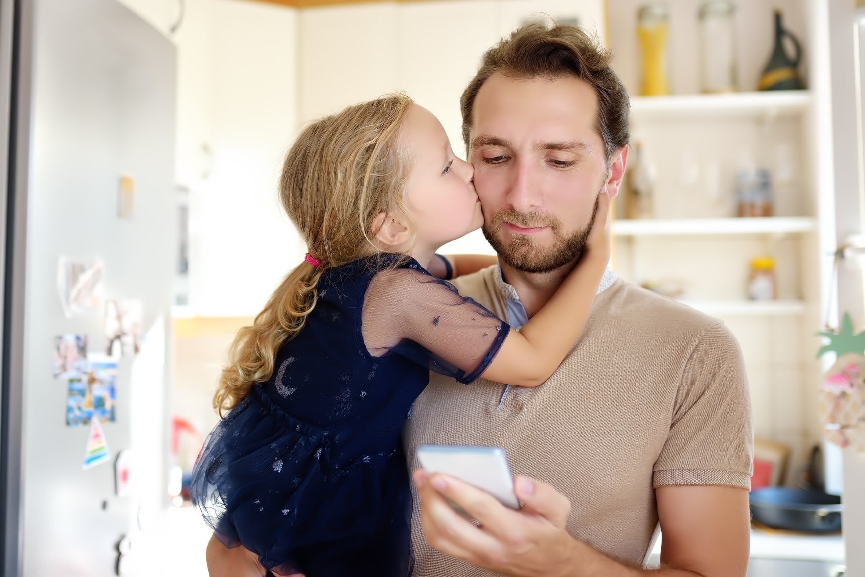 little girl kissing dad on the cheek