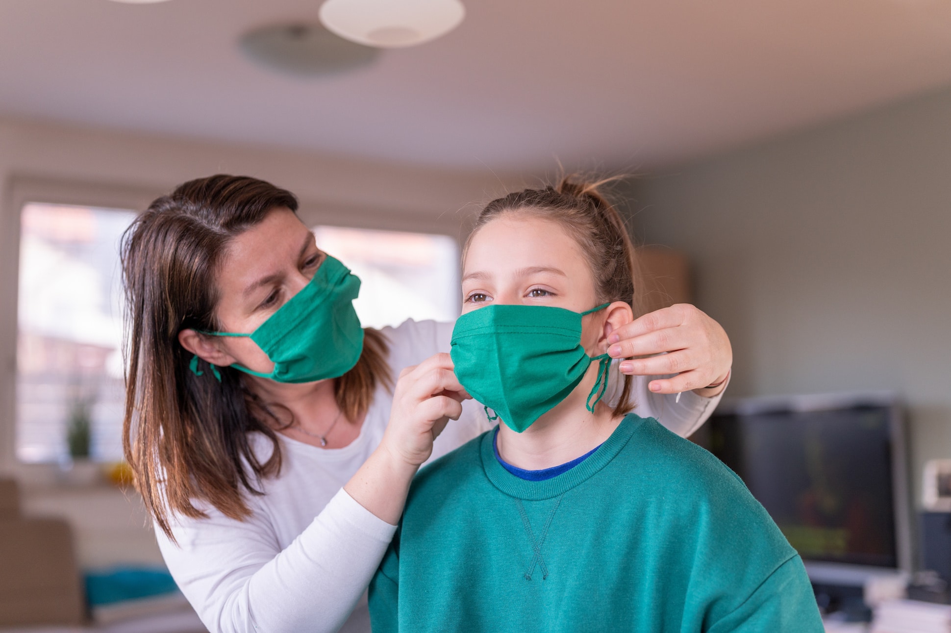 mom putting a mask on her daughter