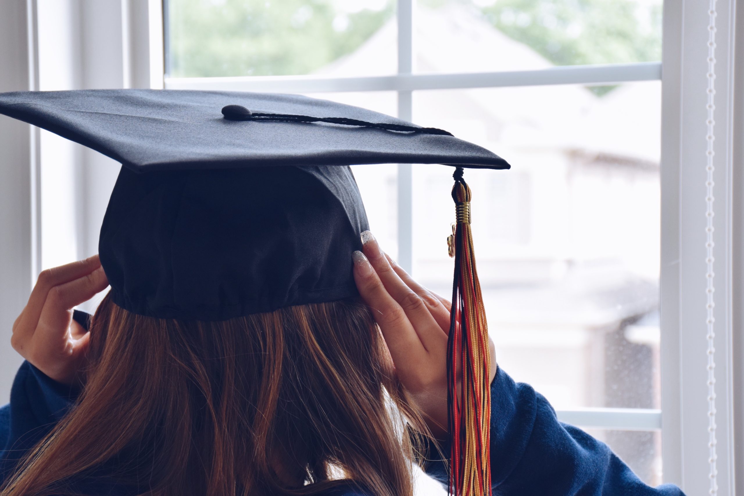 girl putting on her graduation cap