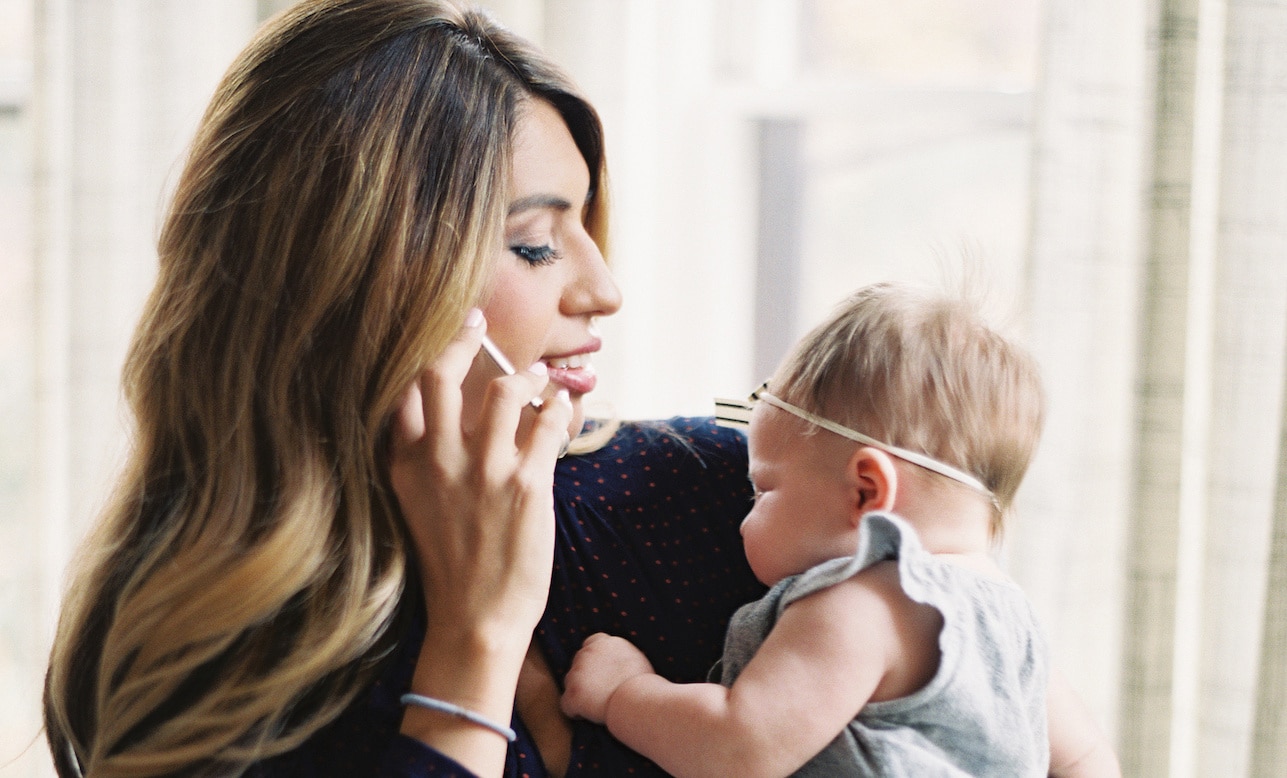 mom on the phone while holding a baby