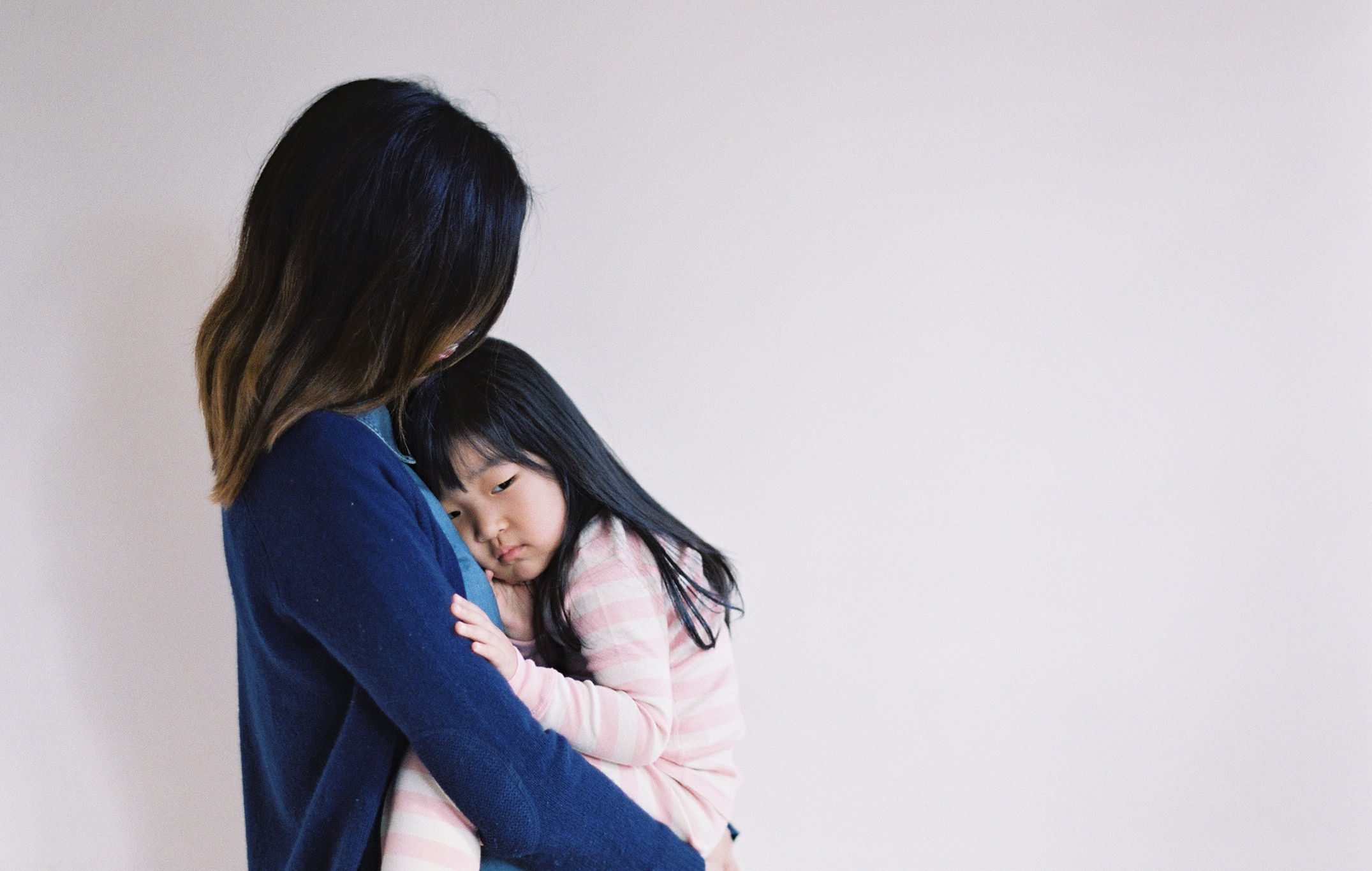 mom holding a sad toddler