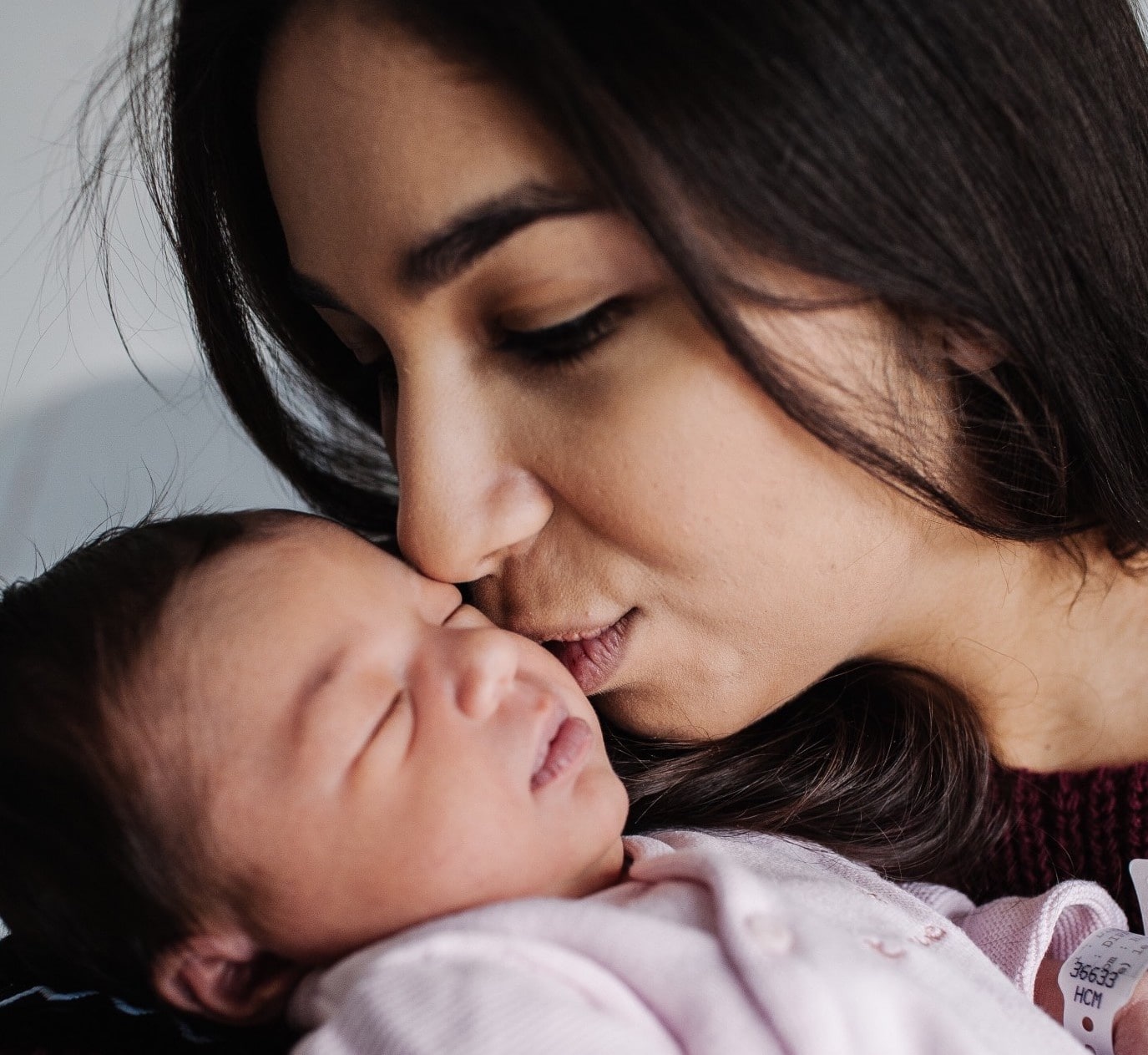 mom postpartum kissing baby