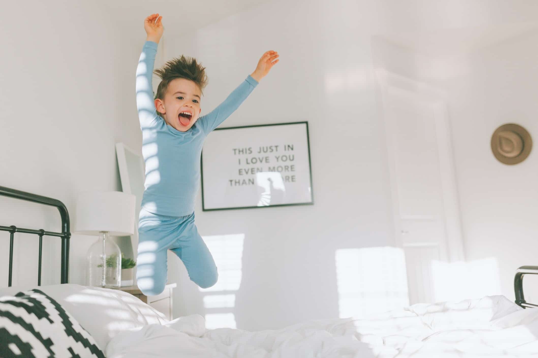 little boy jumping on the bed