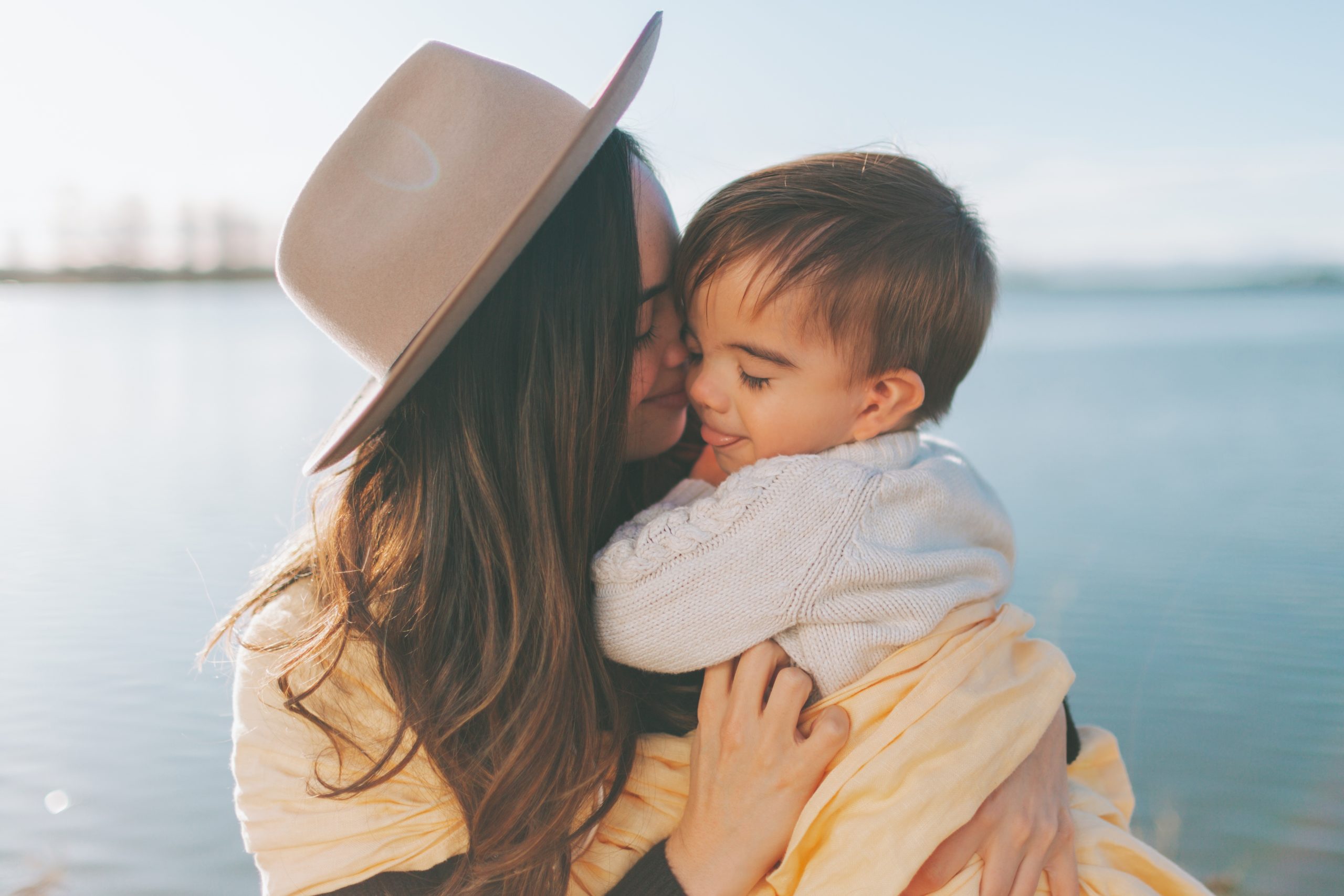 mom kissing toddler boy on the head