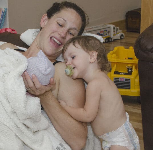 mom showing toddler his new sibling