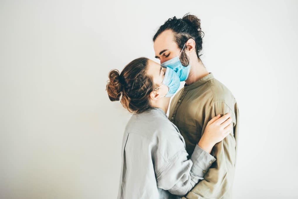 couple kissing through masks
