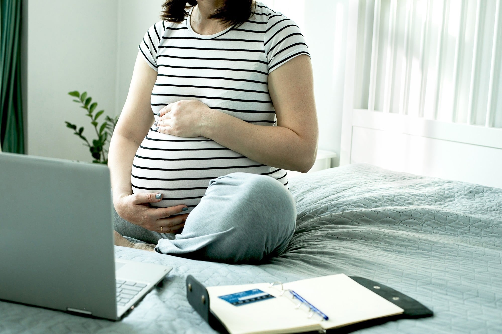 pregnant woman working in her bed