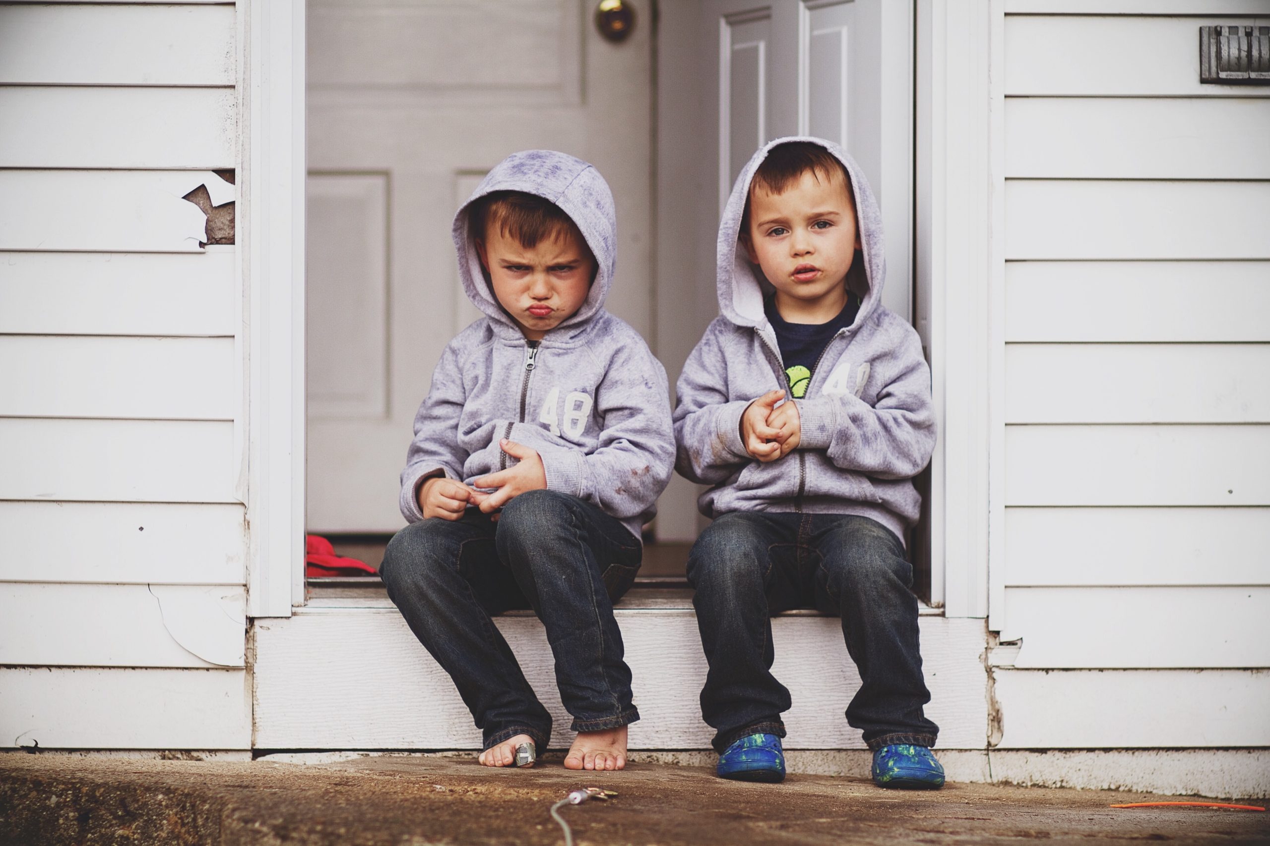 siblings sitting on a doorstep