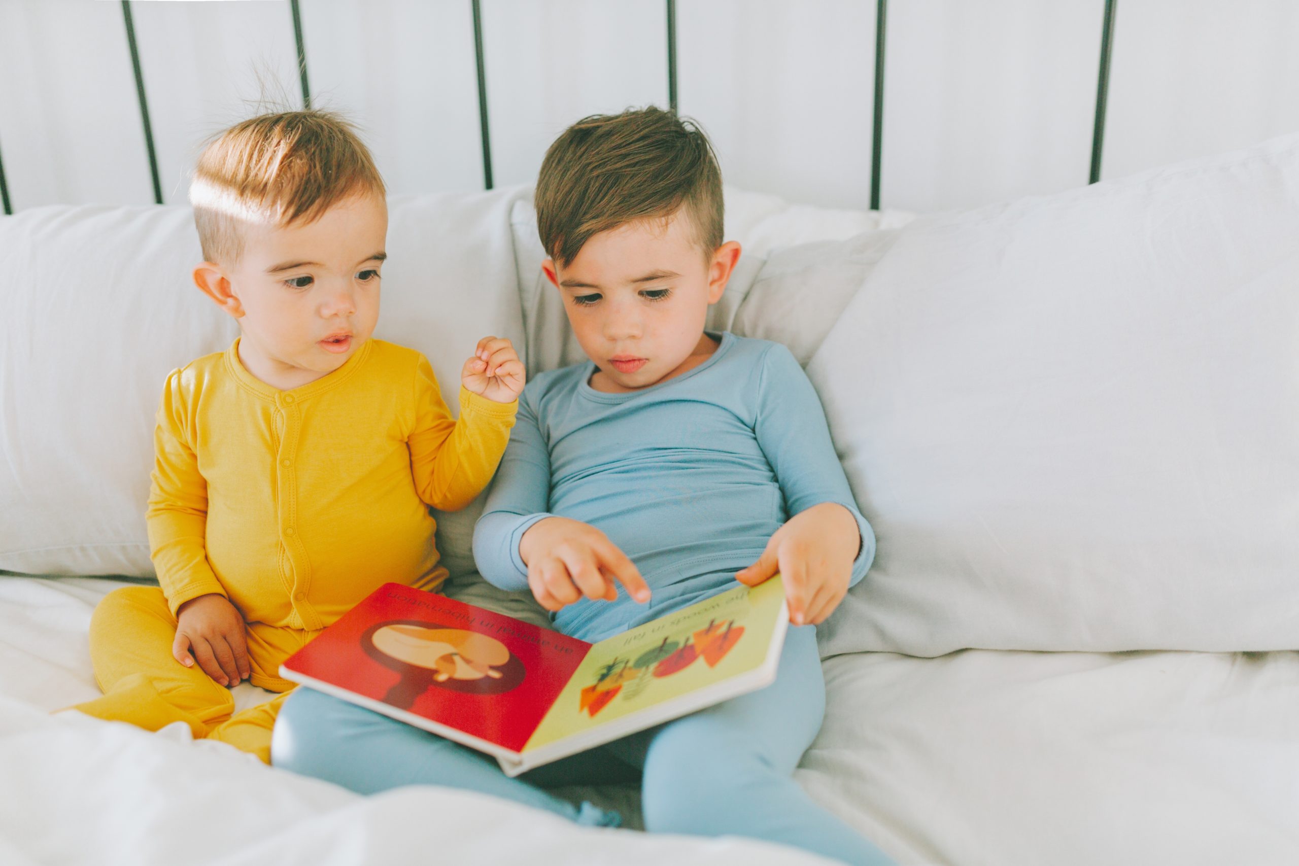 two siblings reading a book together