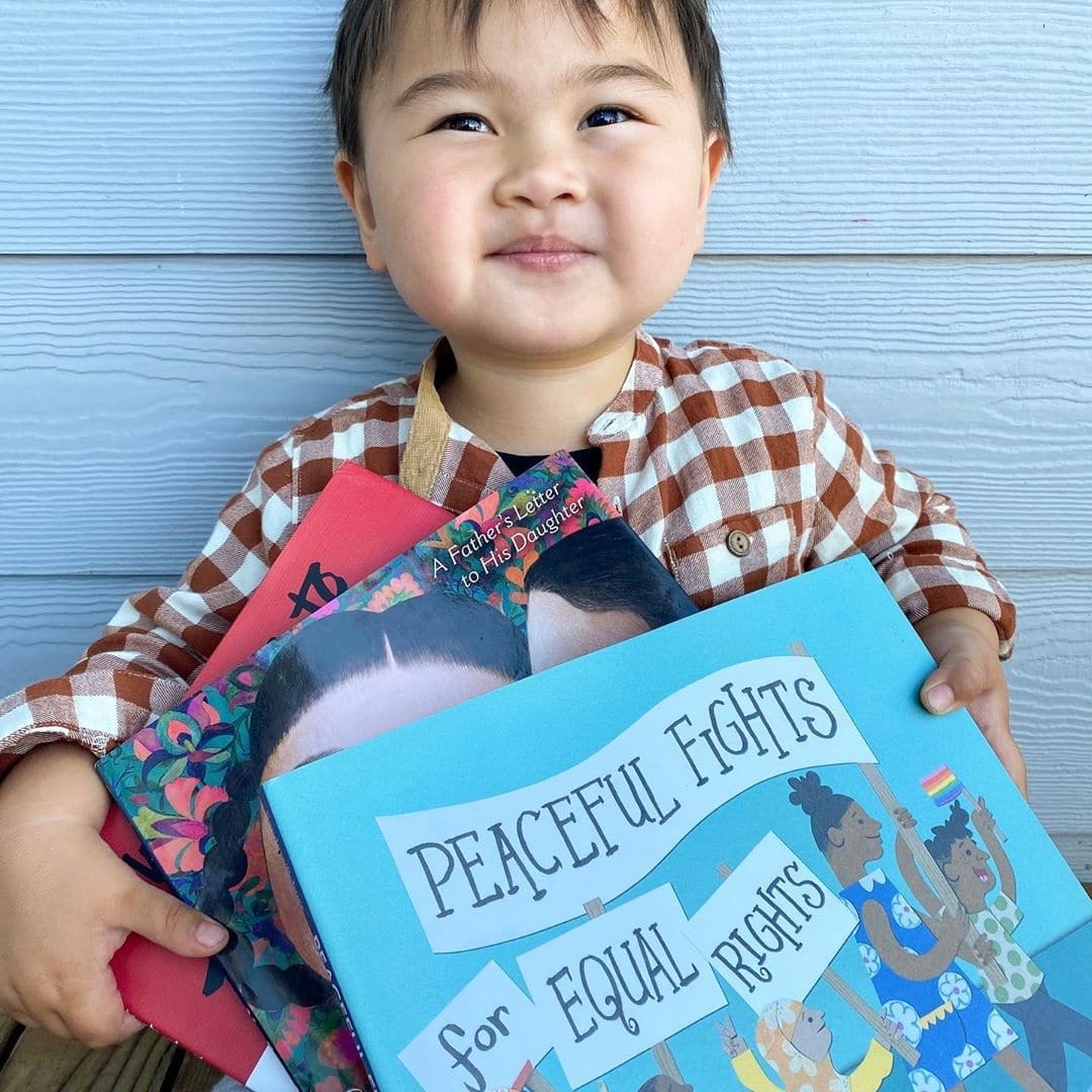 little boy holding a book