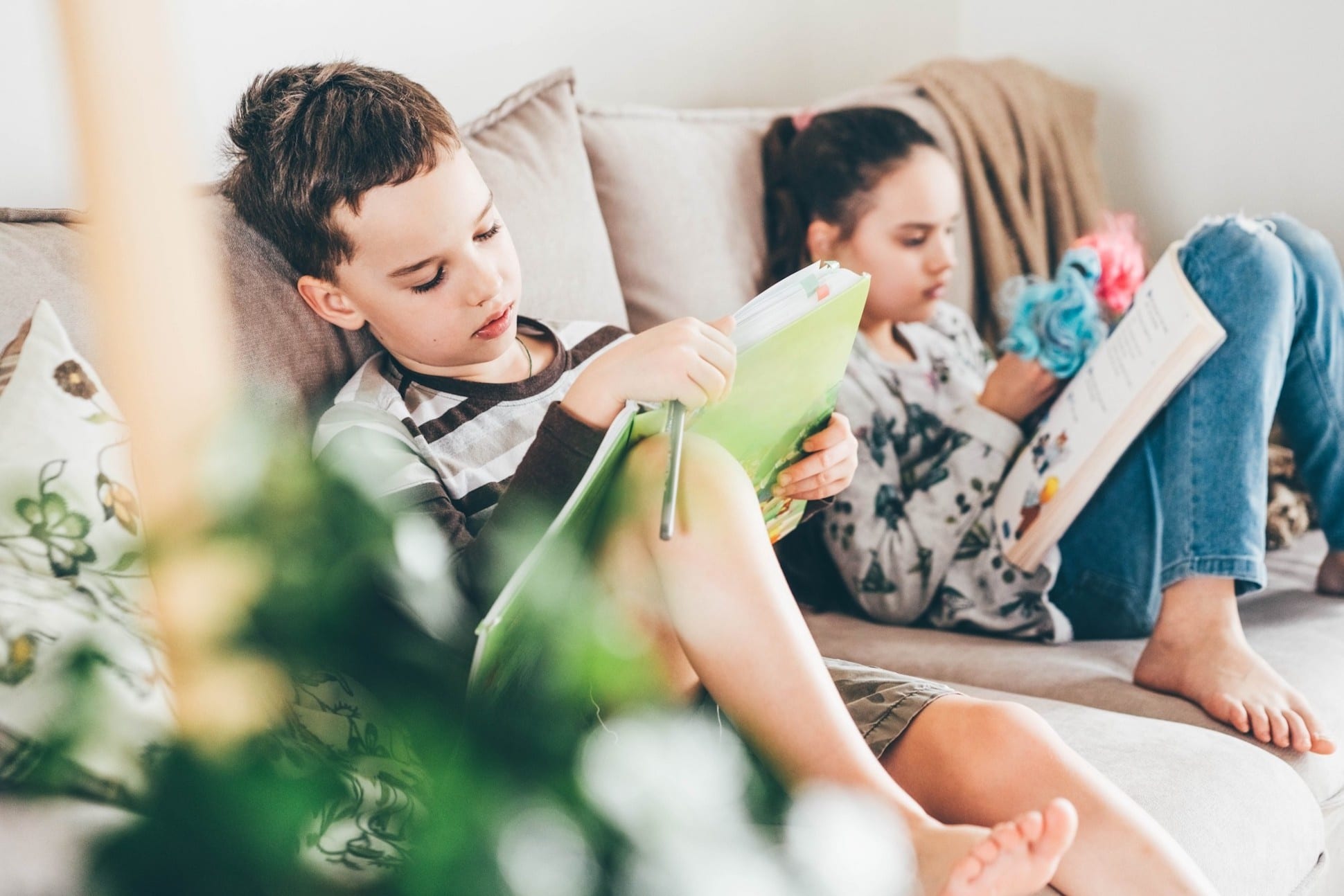 two kids reading on the couch