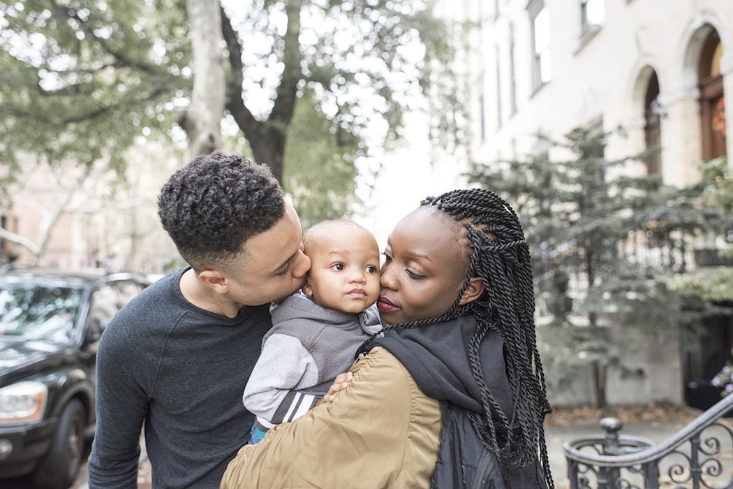 couple kissing their baby on the cheeks