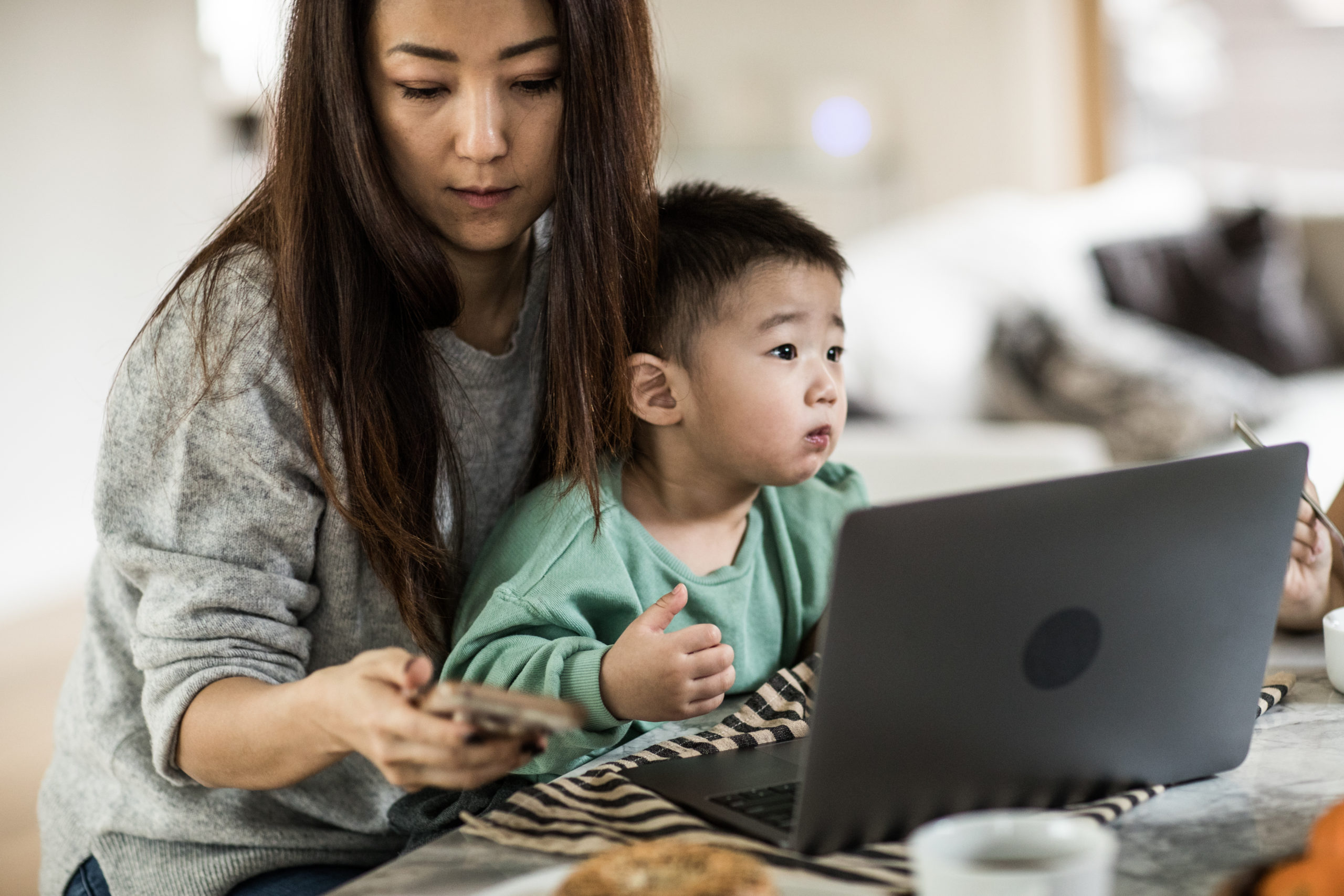 mom working with toddler sitting on her lap