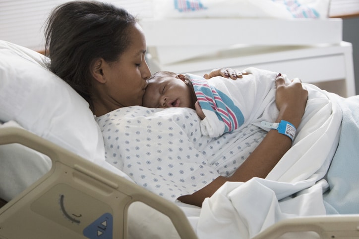 black midwives and black maternal health: mother holding newborn in hospital