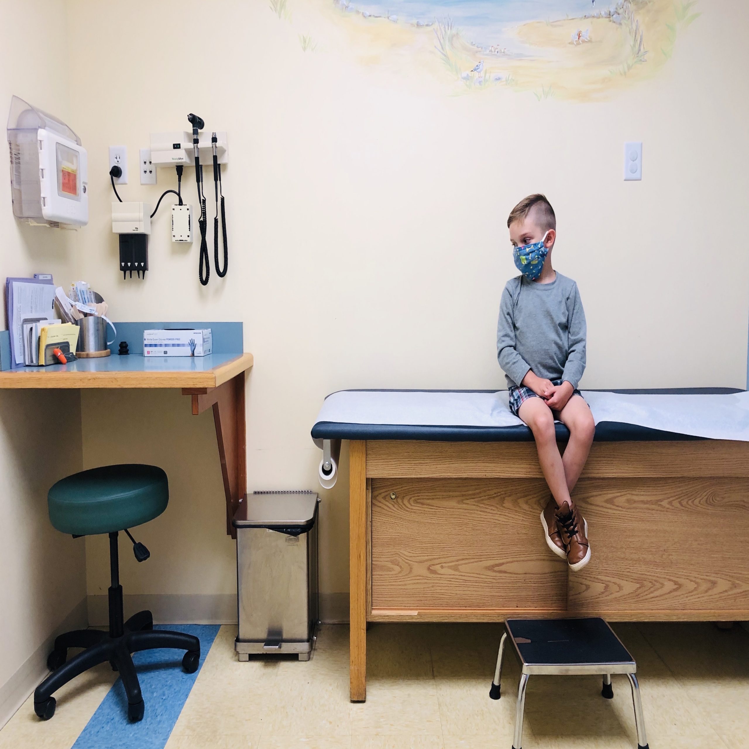 little boy sitting on a pediatrician table