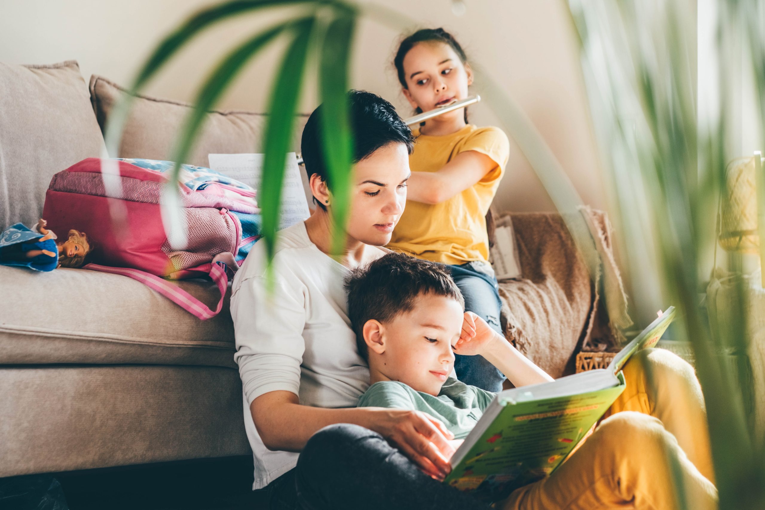 mom reading a book to two kids