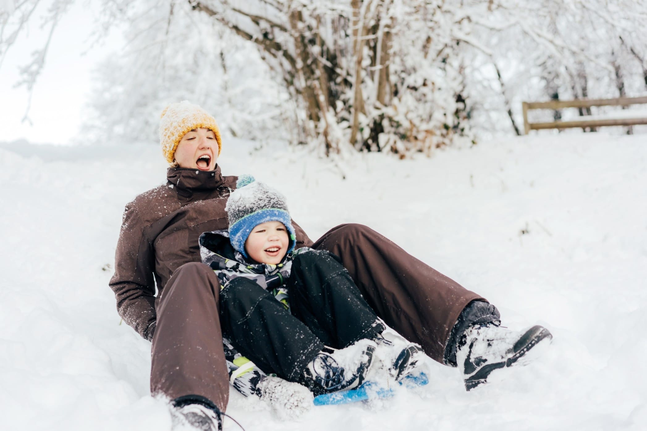 dad and child sledding down a hill
