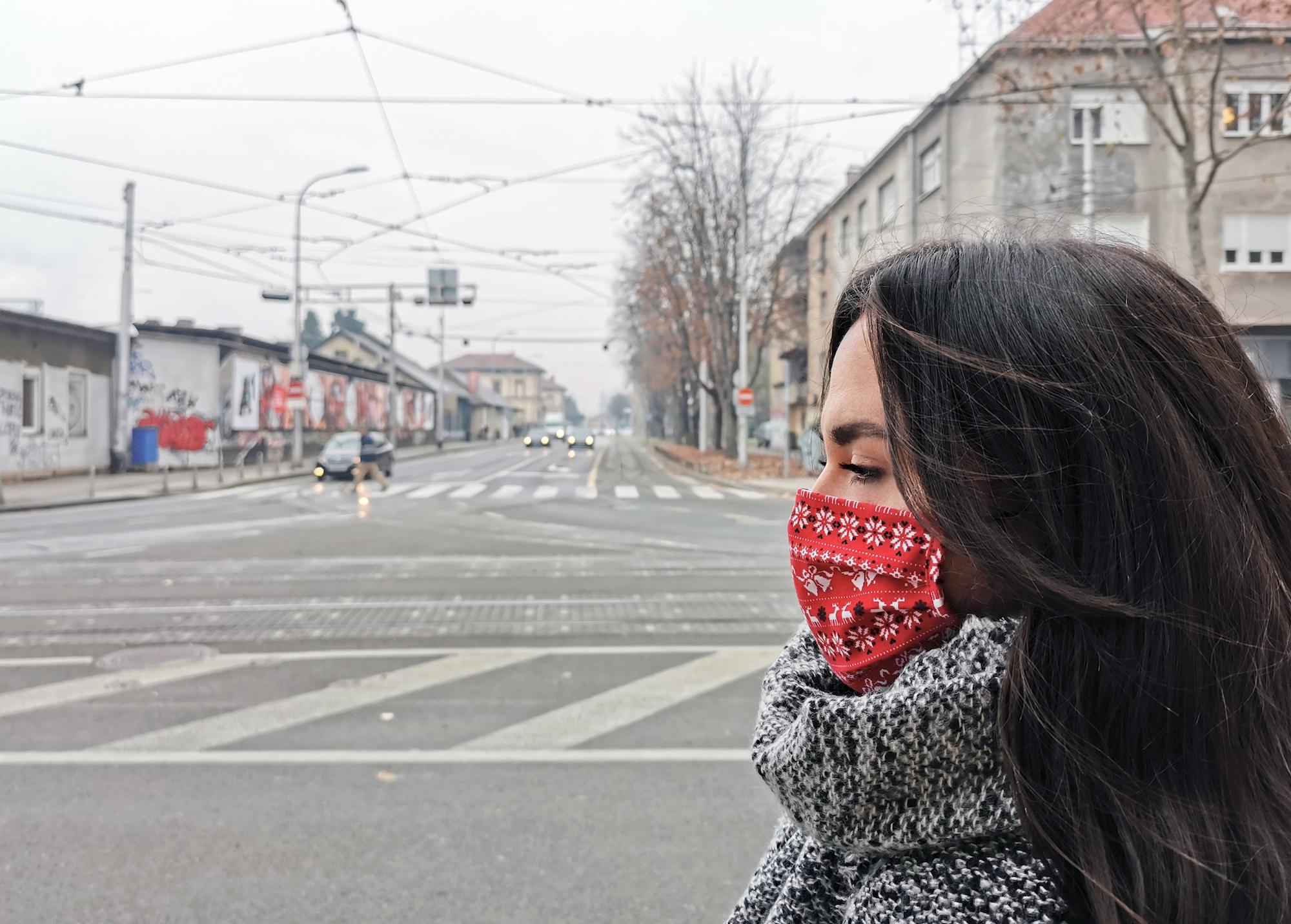 woman wearing a mask walking down the street