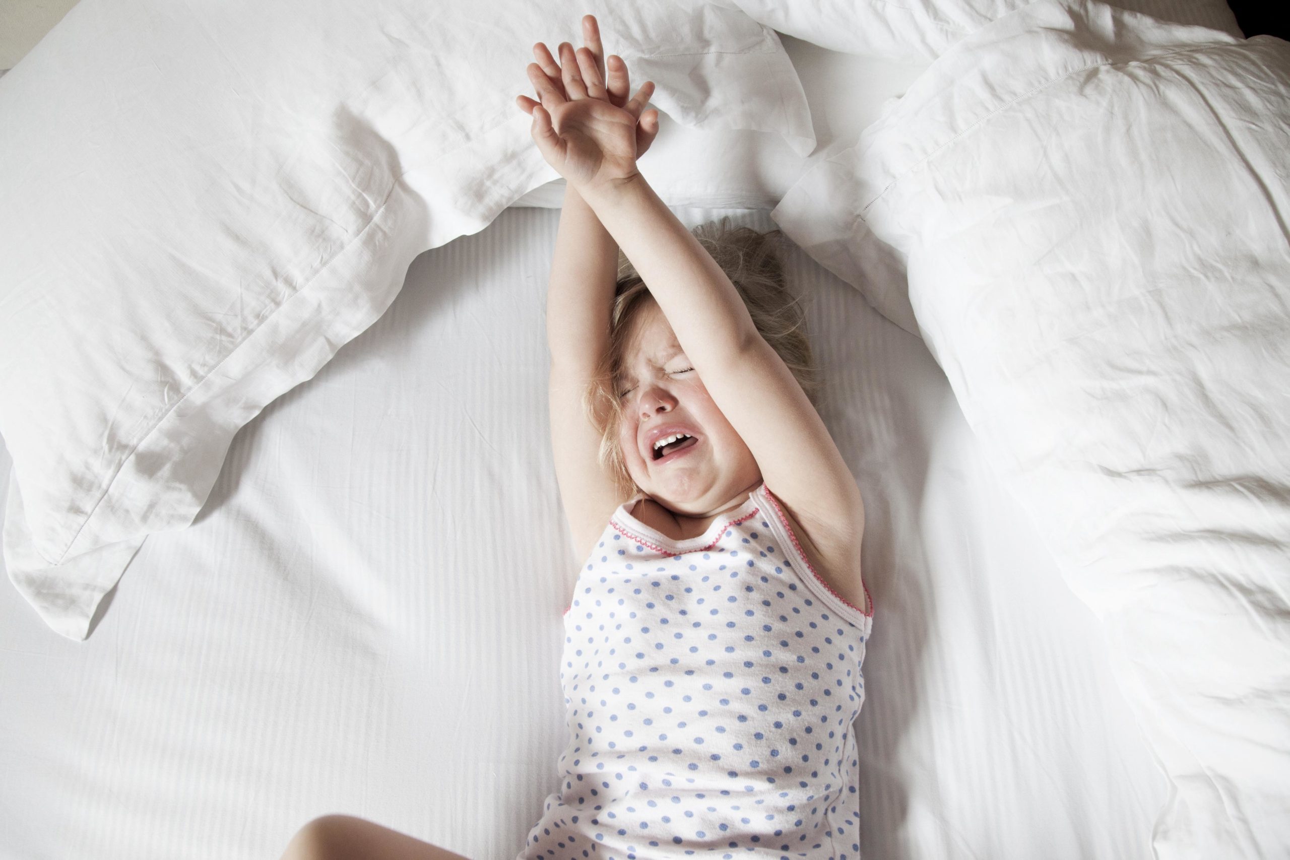 child crying on a bed